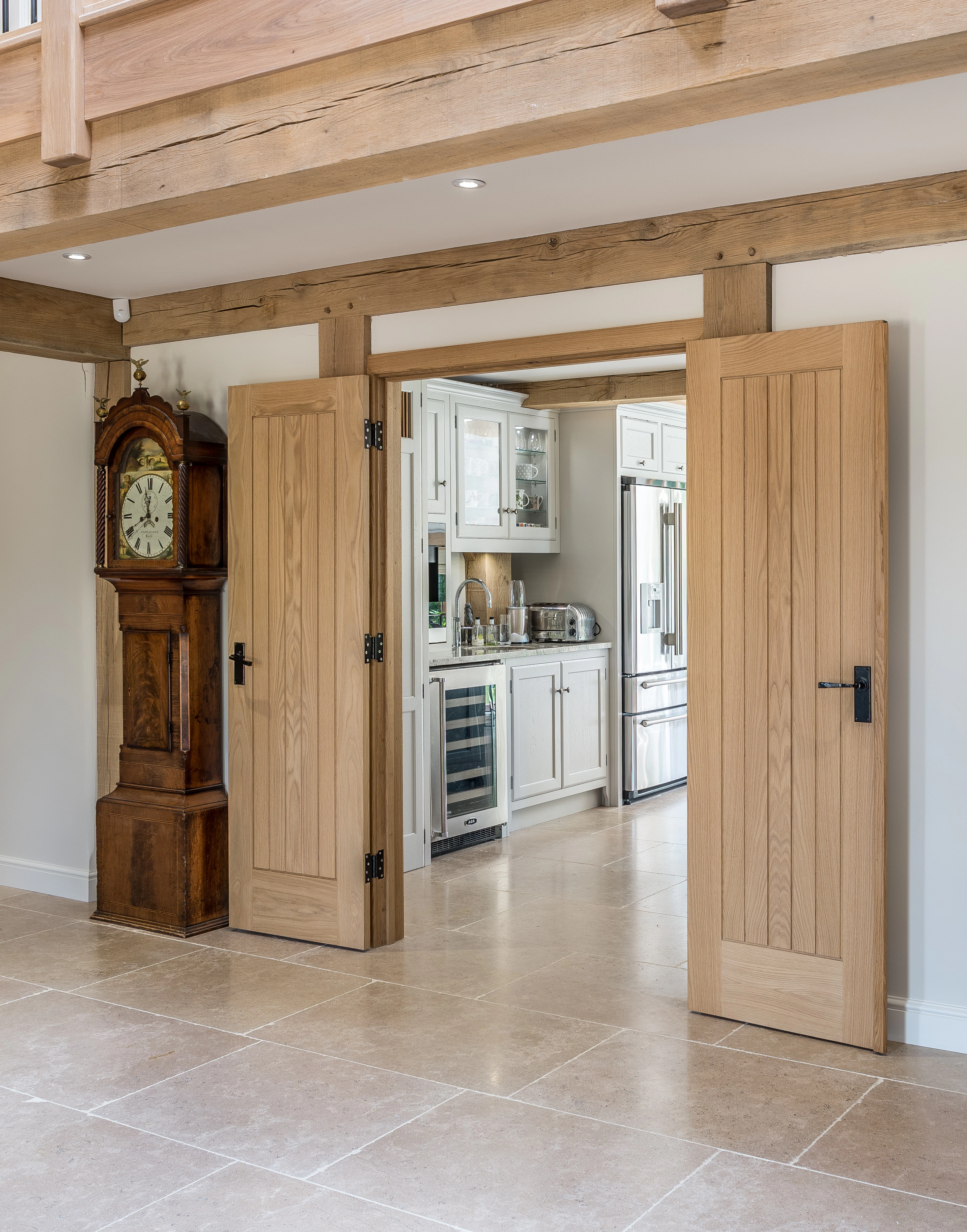 Internal view of an open foyer in an oak-framed family home with double doors leading into the open-plan kitchen and dining room