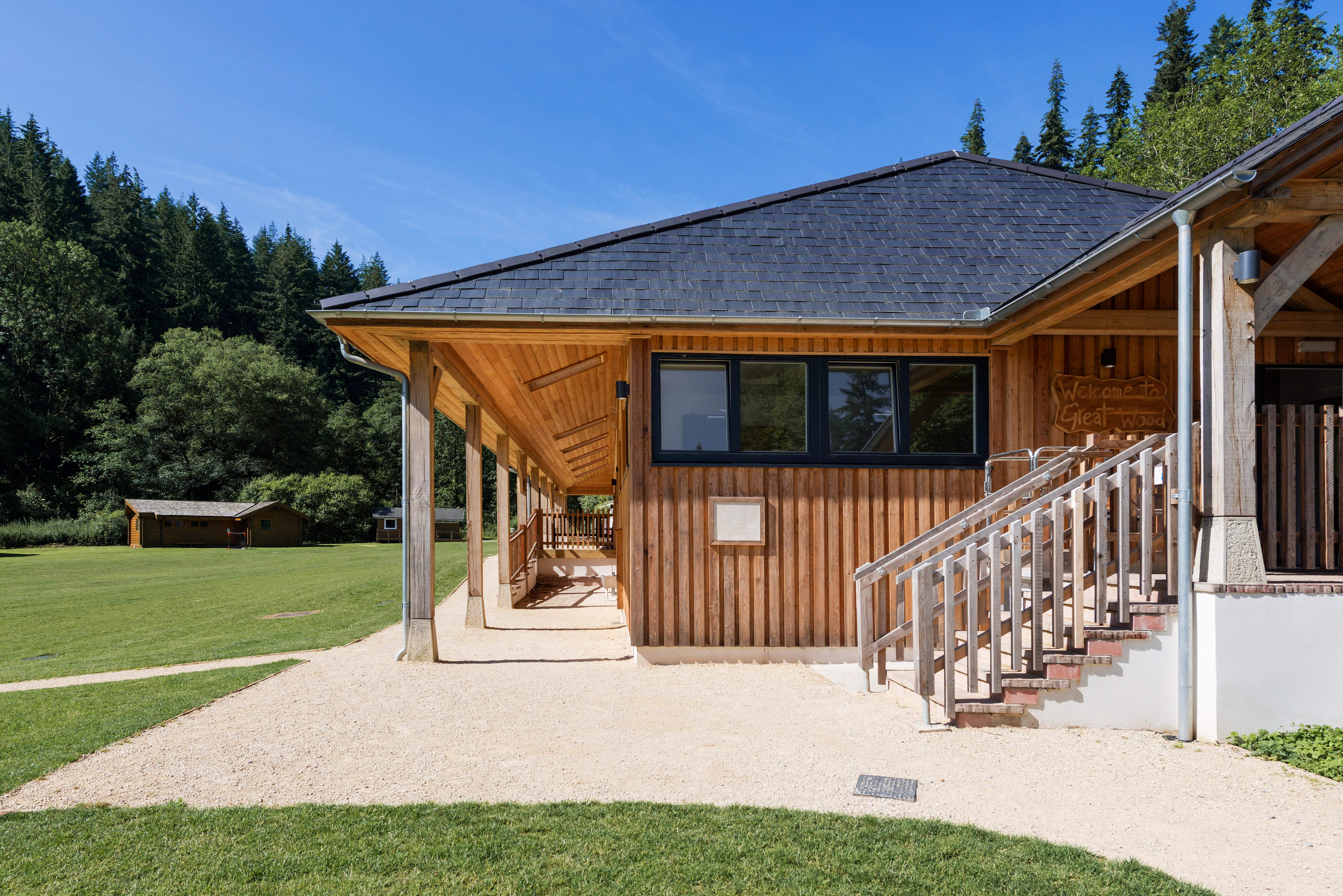 External view of the new multifunctional space at Great Wood Camp, surrounded by woodland