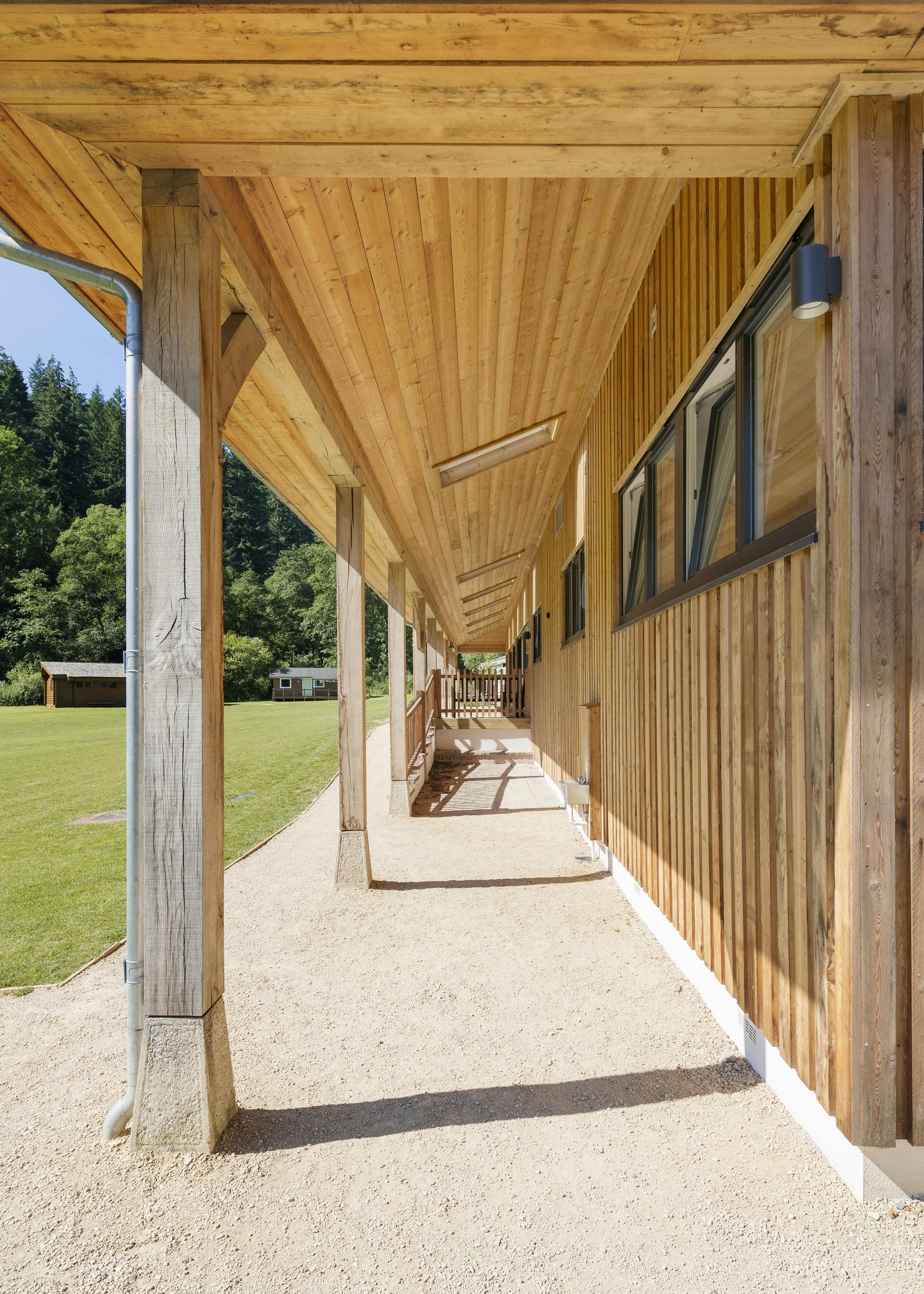 Clad wraparound veranda at Great Wood Camp featuring staddle-stone finishes
