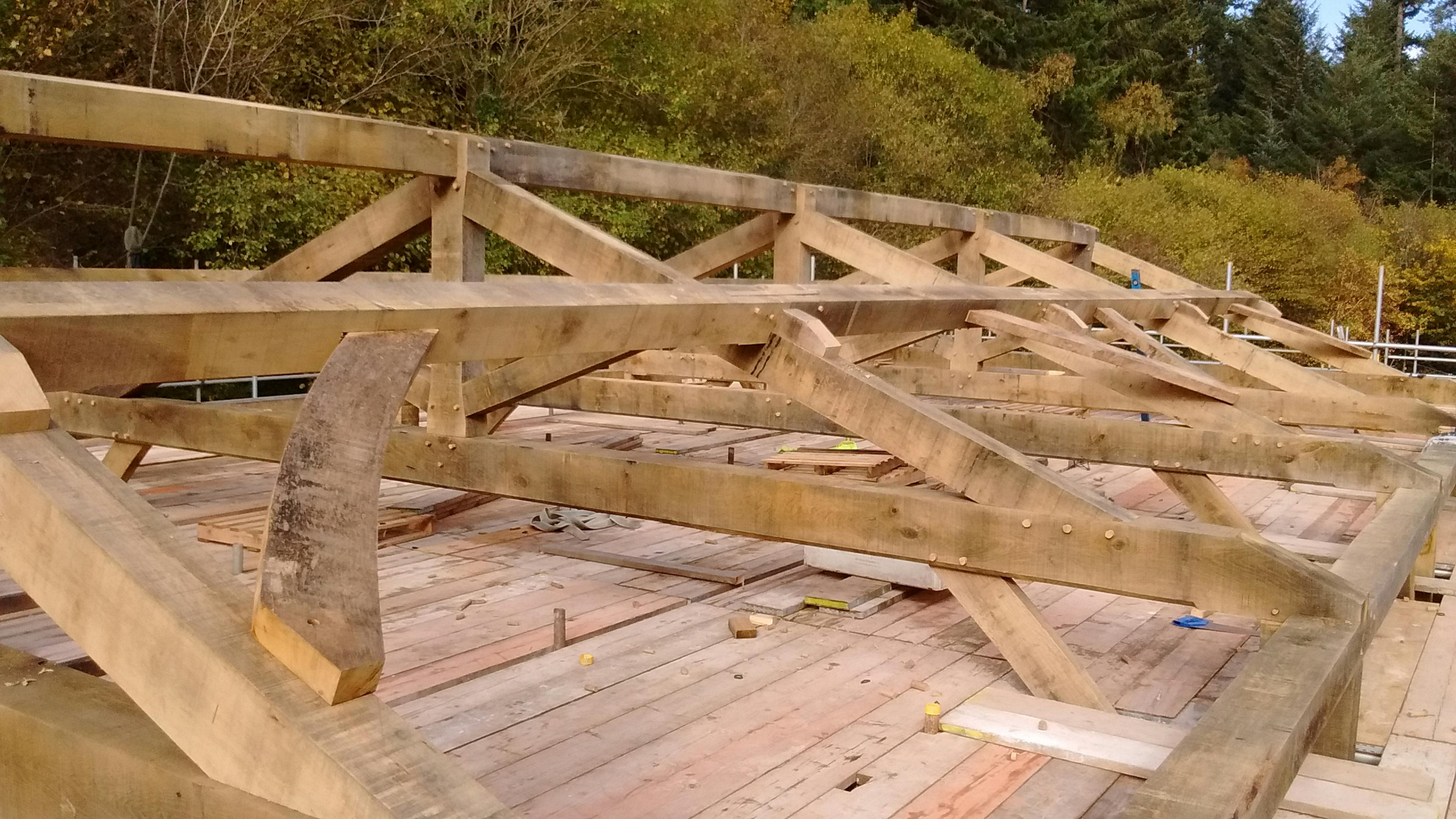 Kingpost trusses being installed as part of the construction at Great Wood Camp