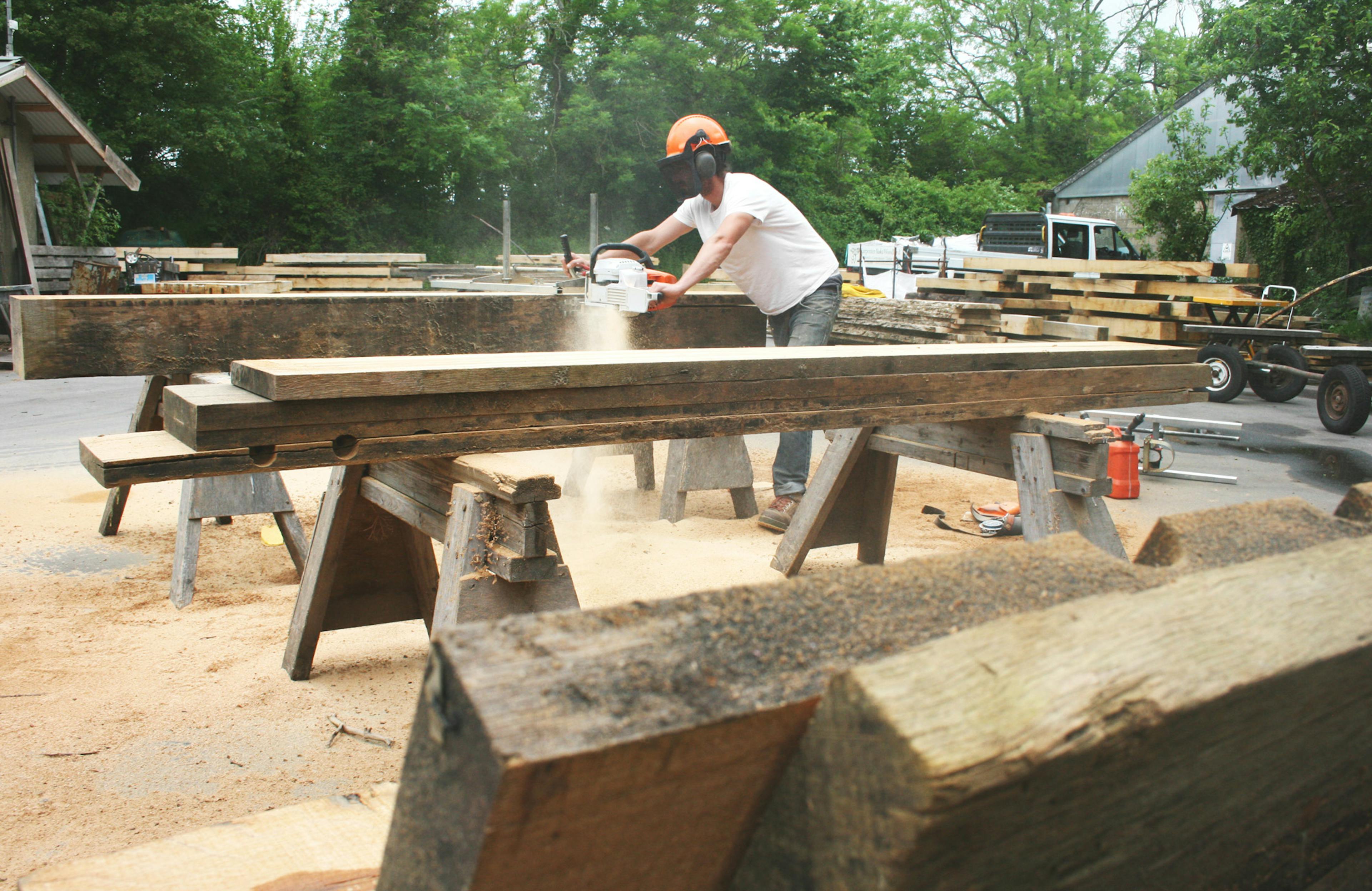 Recycled timber offcuts being sawn in yard for an art installation by carpenter