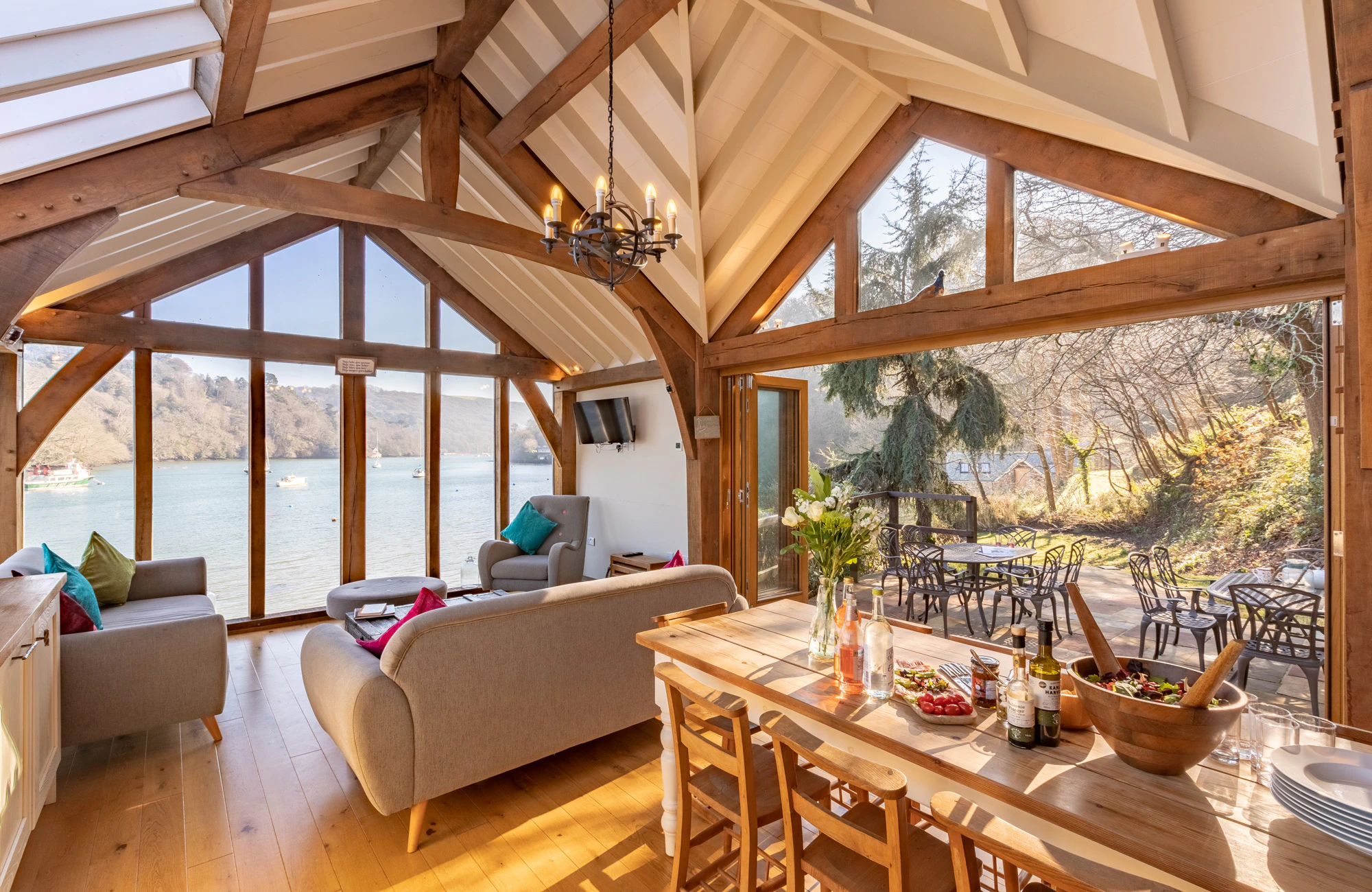 An internal view of an oak-framed cottage resting on the edge of an estuary, blending rustic charm with scenic coastal surroundings