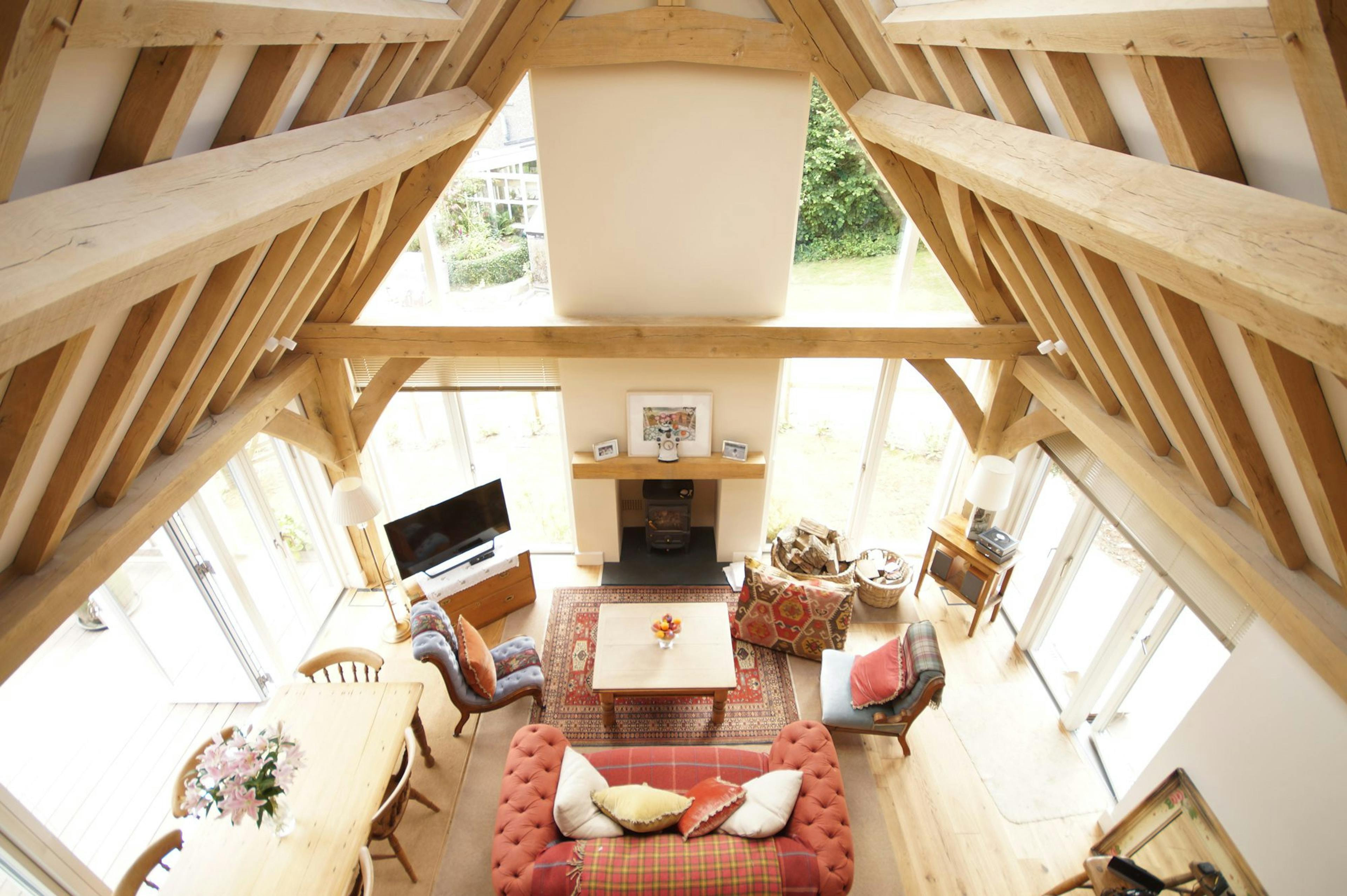 Oak-framed living space with vaulted ceilings and a central fireplace