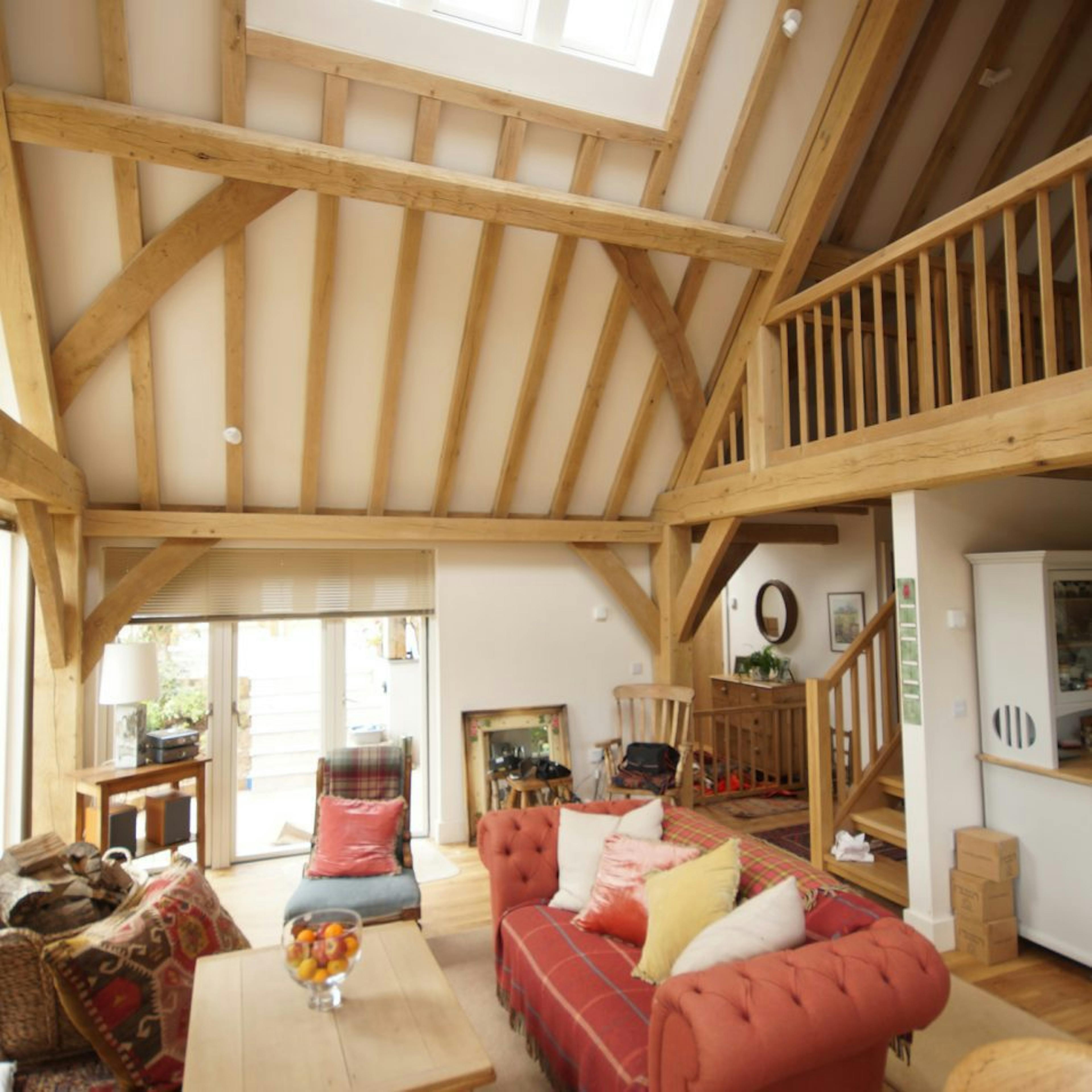 Oak-framed living space with vaulted ceilings and an overlooking mezzanine