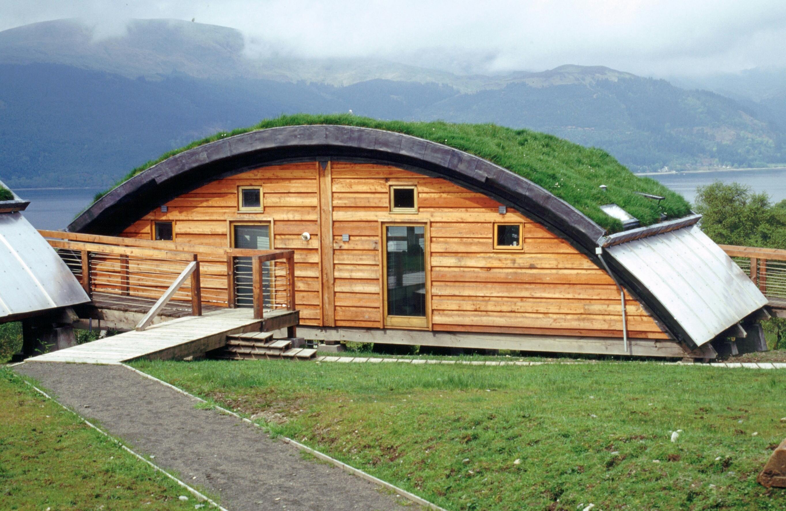 Green oak and Douglas fir clad cabins with a turfed curved roof