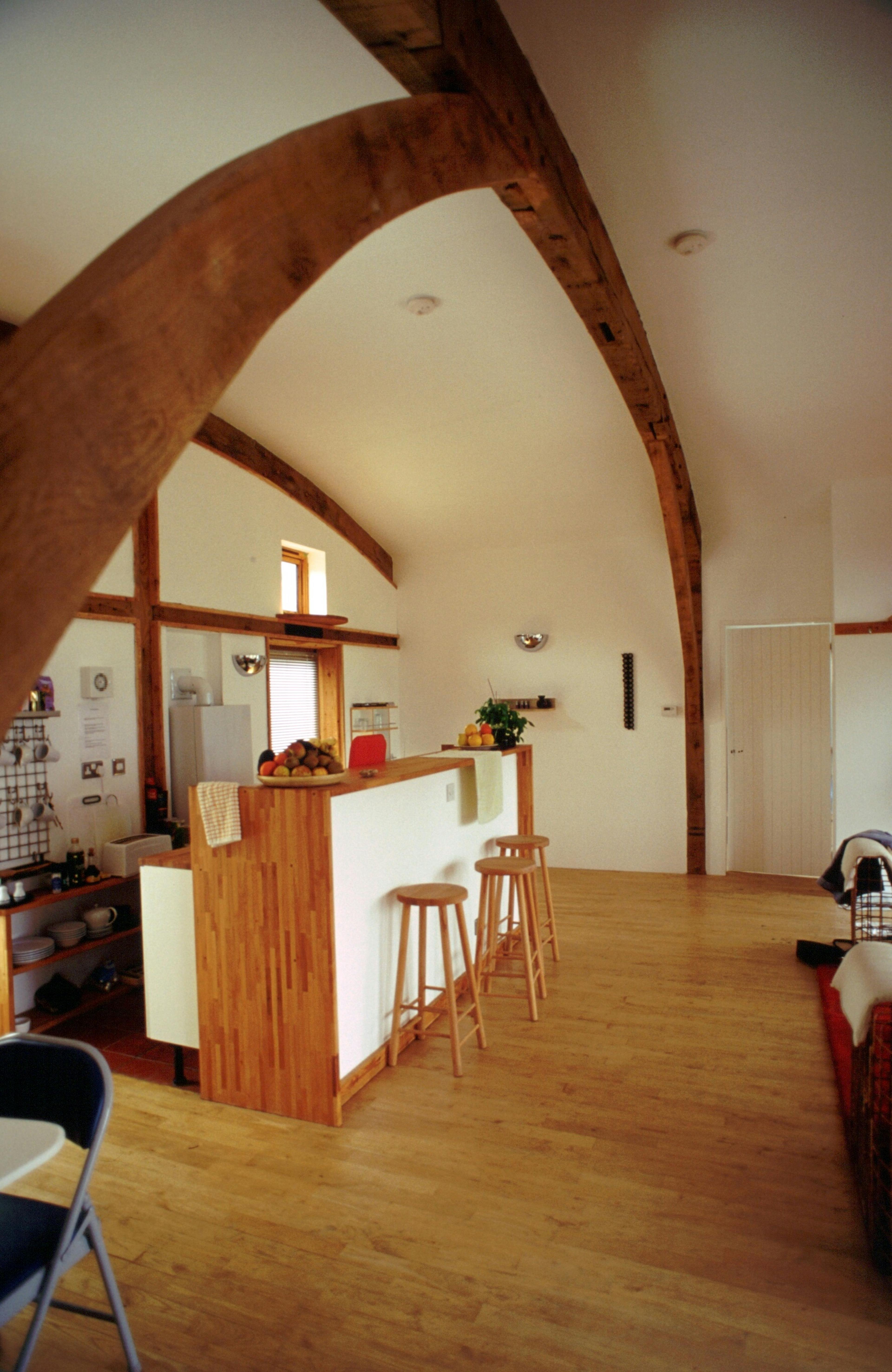 Interior of a green oak and Douglas fir clad cabin showing the kitchen area