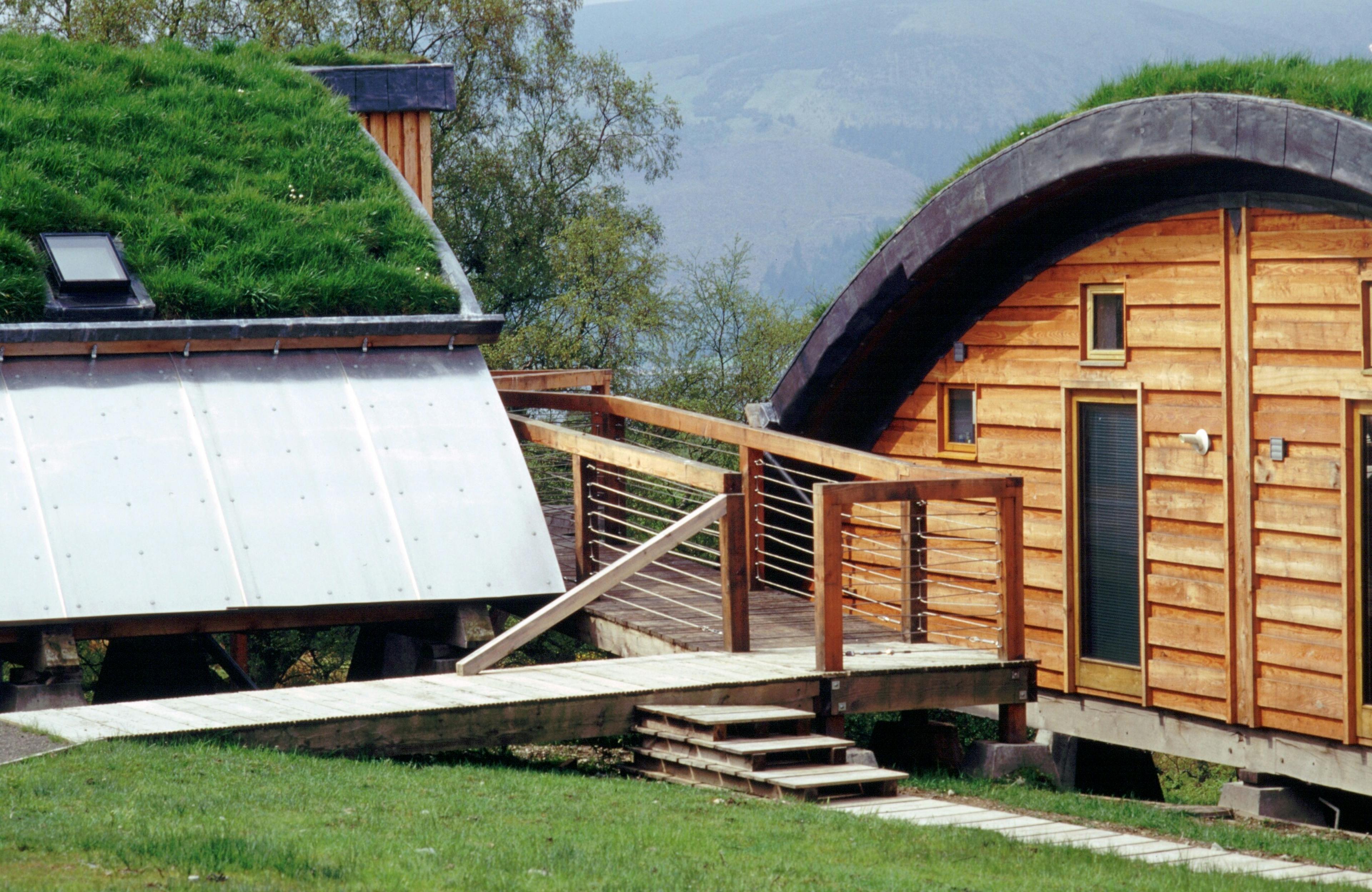 Green oak and Douglas fir clad cabins with a turfed curved roof