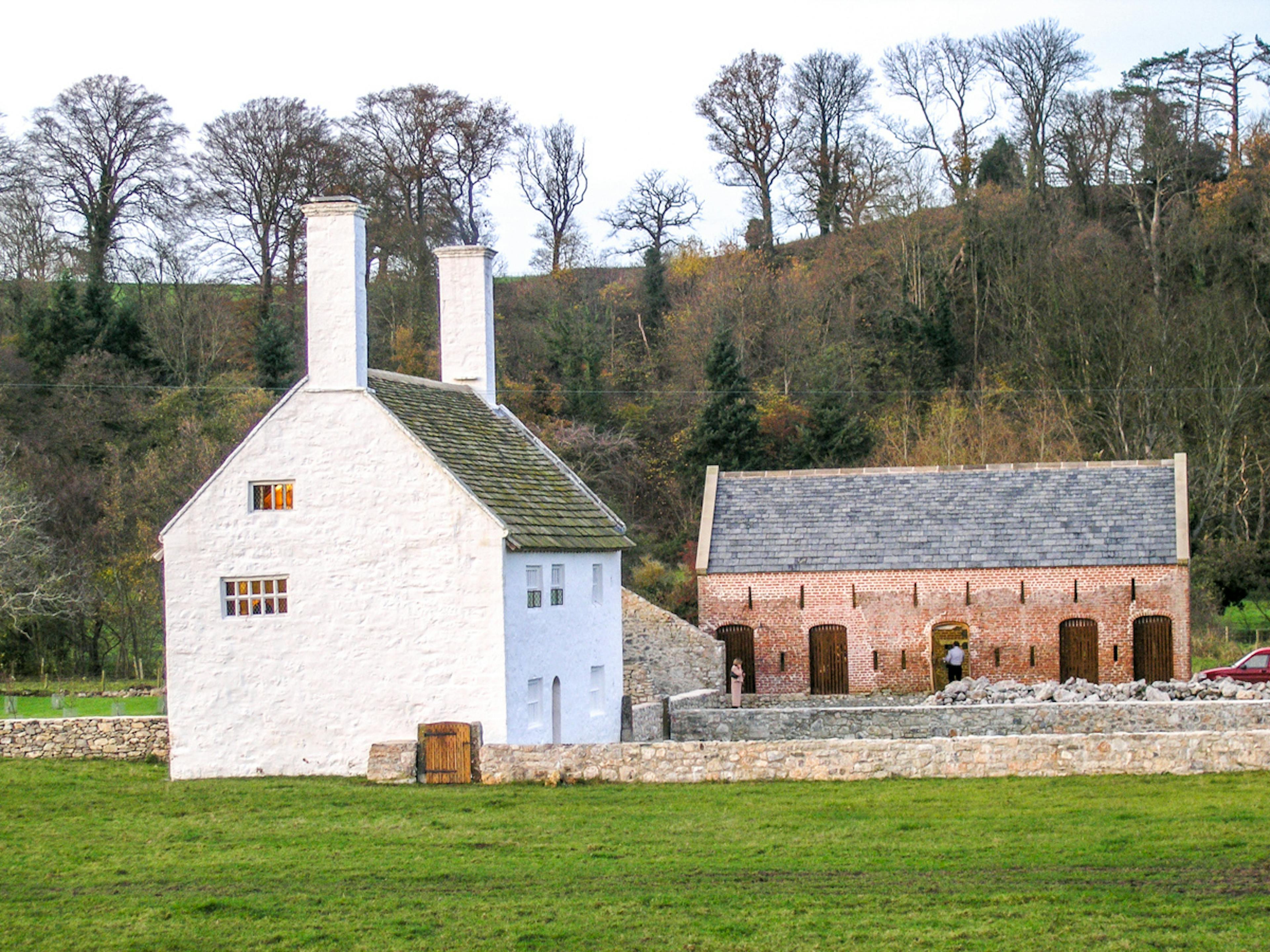 Exterior view of a restored 16th century house and barn in Wales