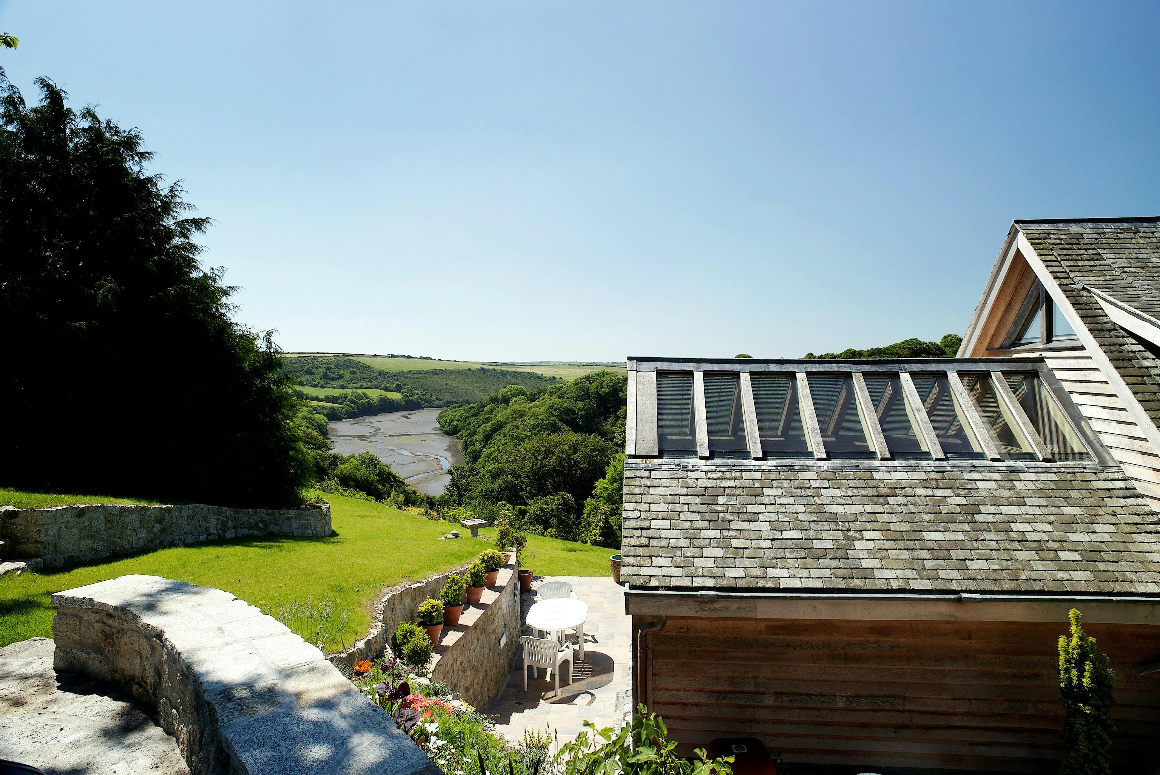 View of the estuary from an oak frame home built on a slope with green lawn in front