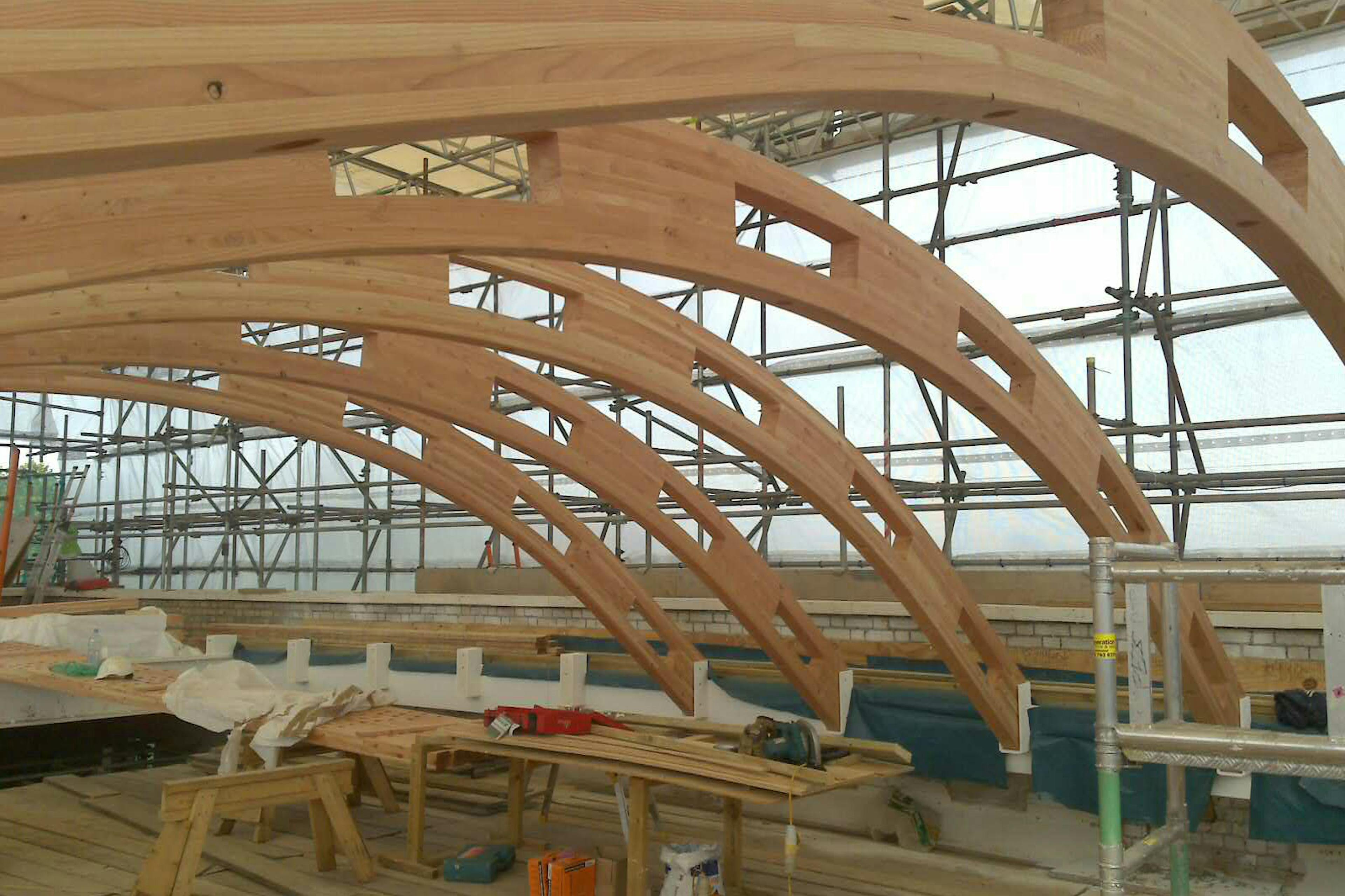 A close up of a glulam gridshell roof structure during installation