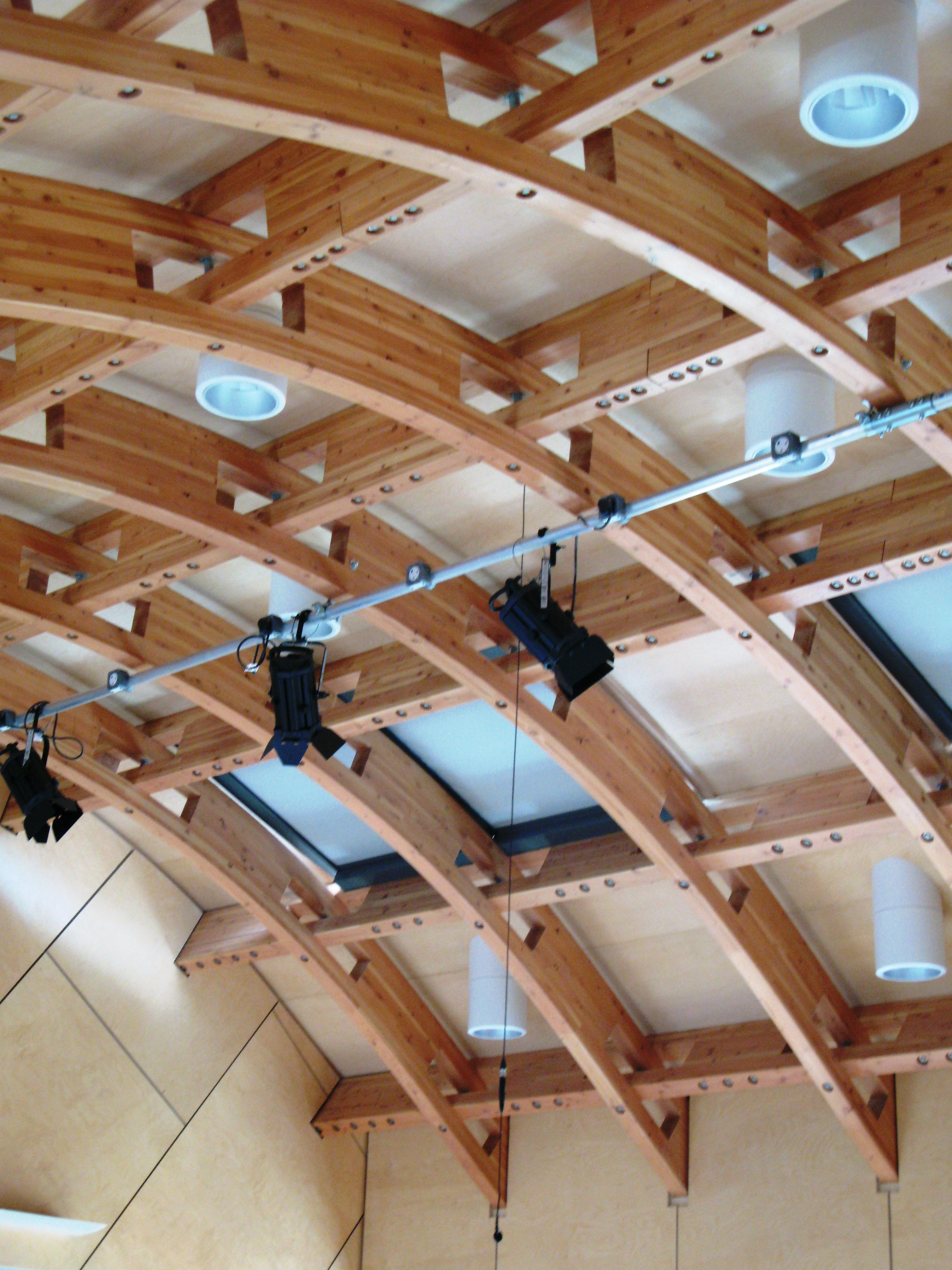 The roof of a glulam gridshell structure with a row of theatre lights