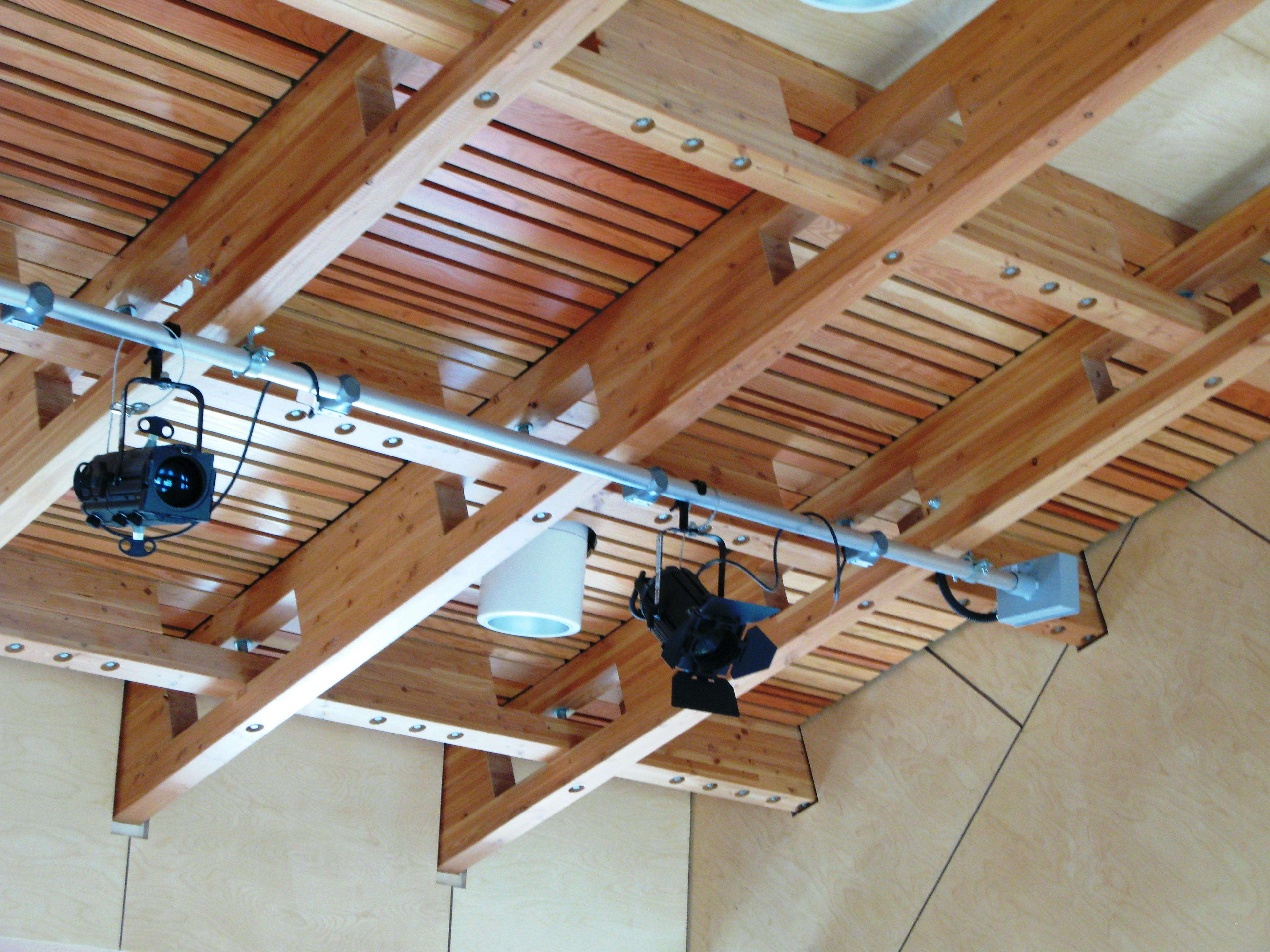 The roof of a glulam gridshell structure with a row of theatre lights