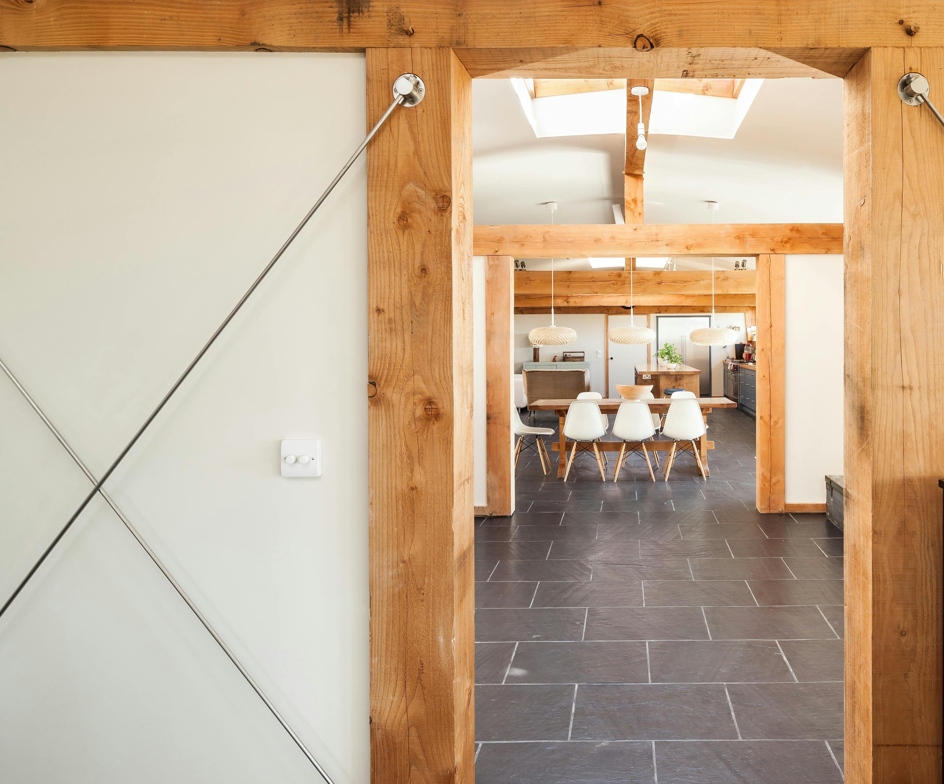 The dining area in a Douglas fir framed family farmhouse can be seen through a doorway