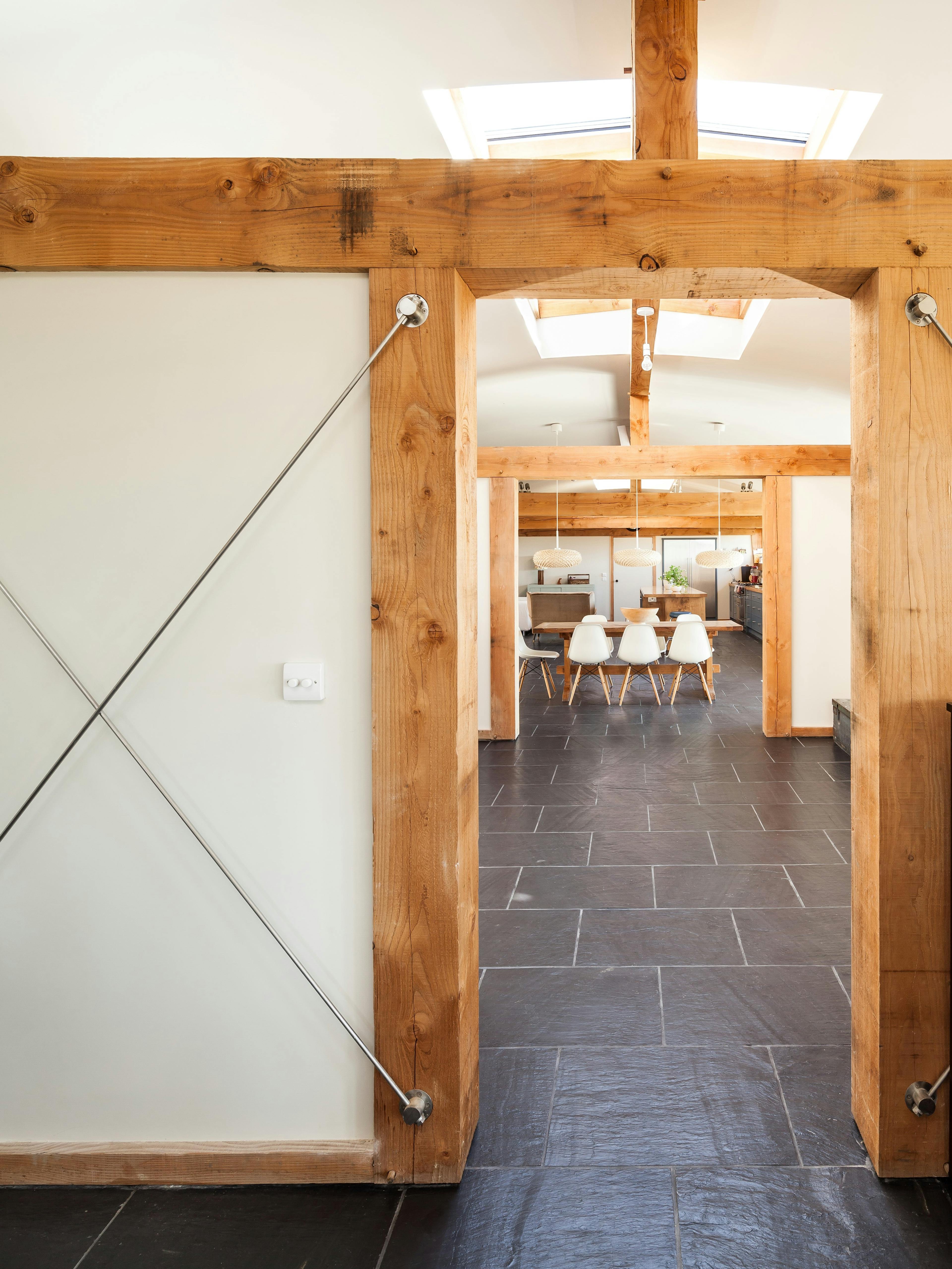 The dining area in a Douglas fir framed family farmhouse can be seen through a doorway