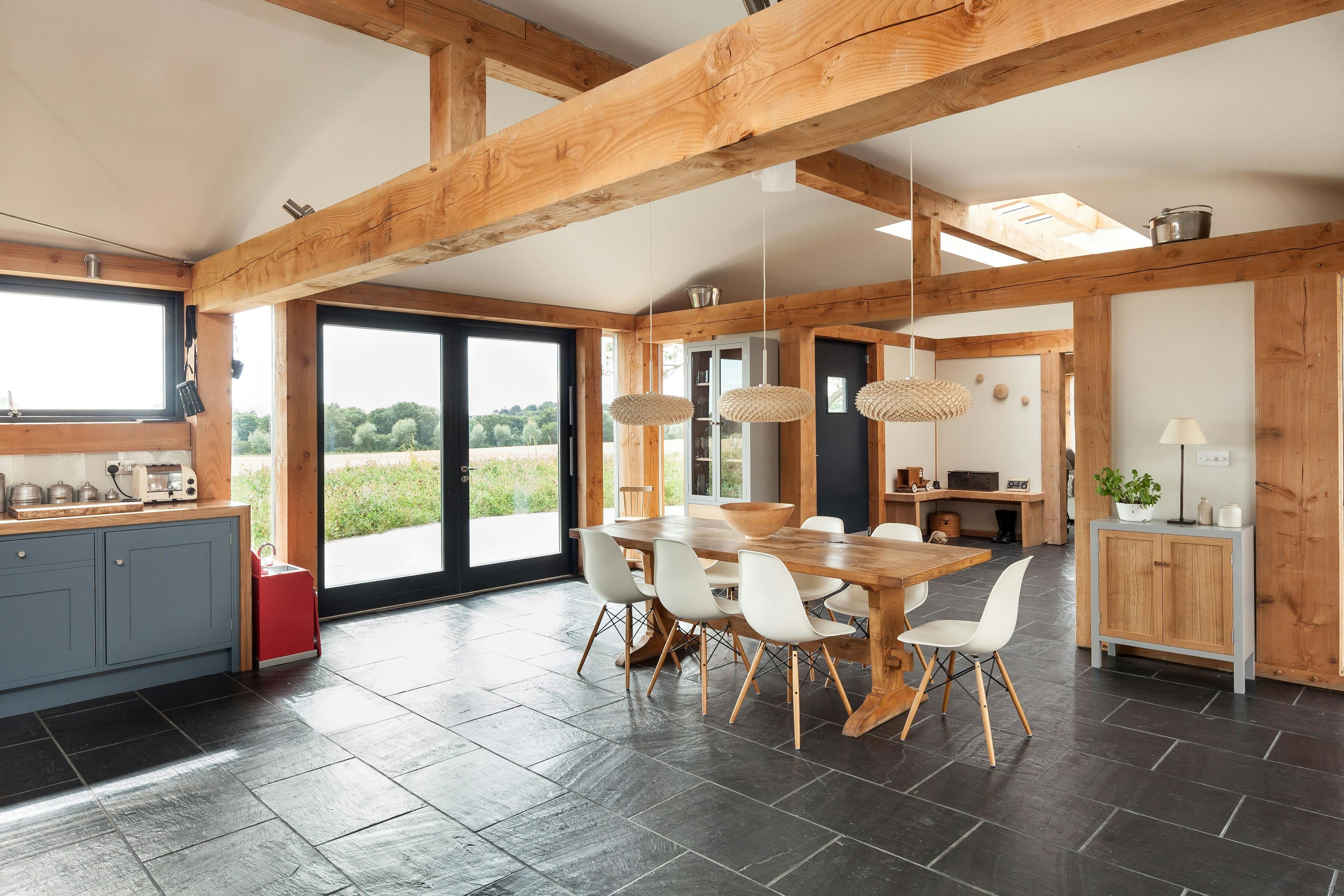 The dining area of a Douglas fir framed family farmhouse with large dark grey flagstone