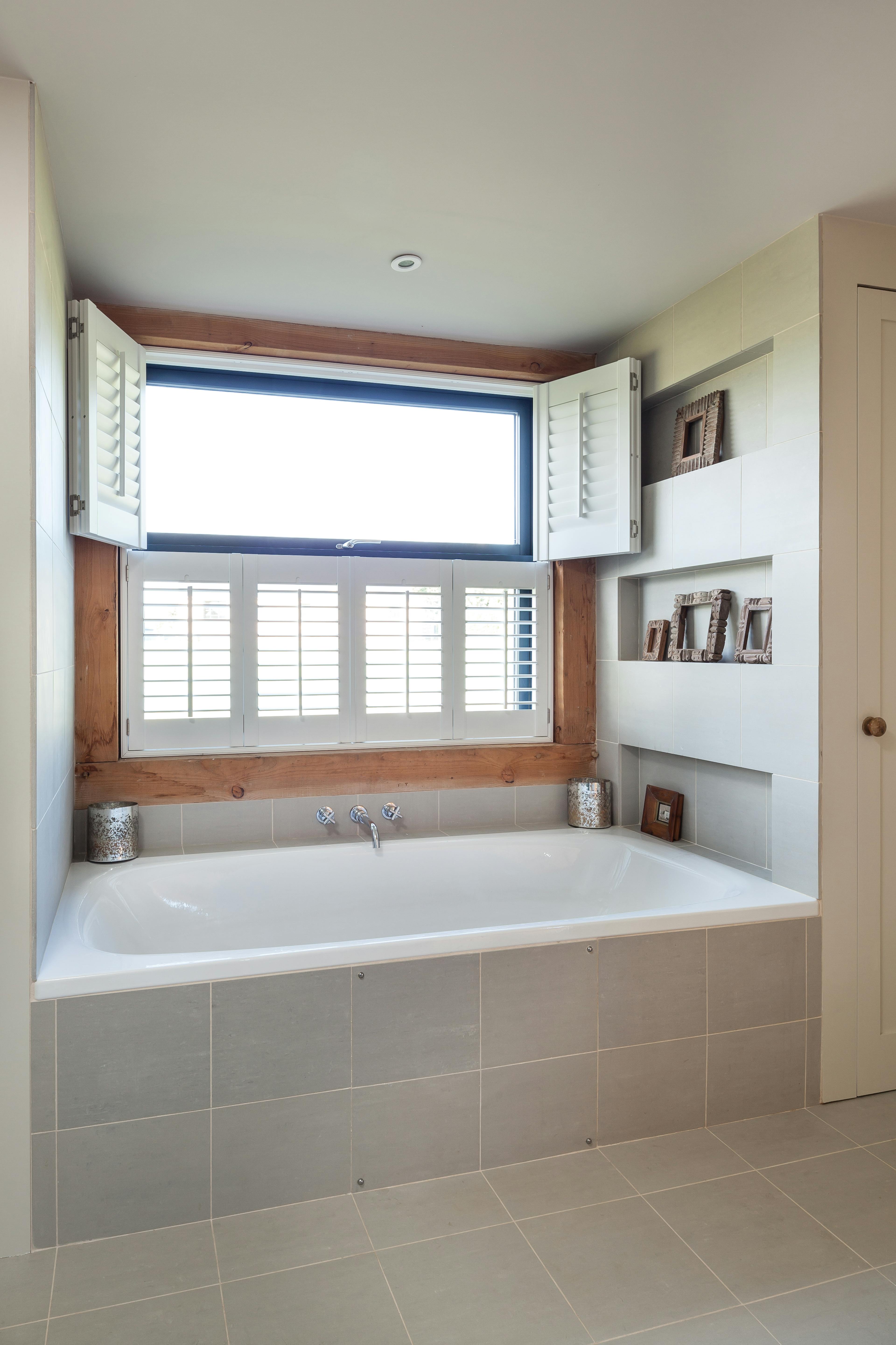 The bathroom in a Douglas fir framed family farmhouse with a bath below an open window