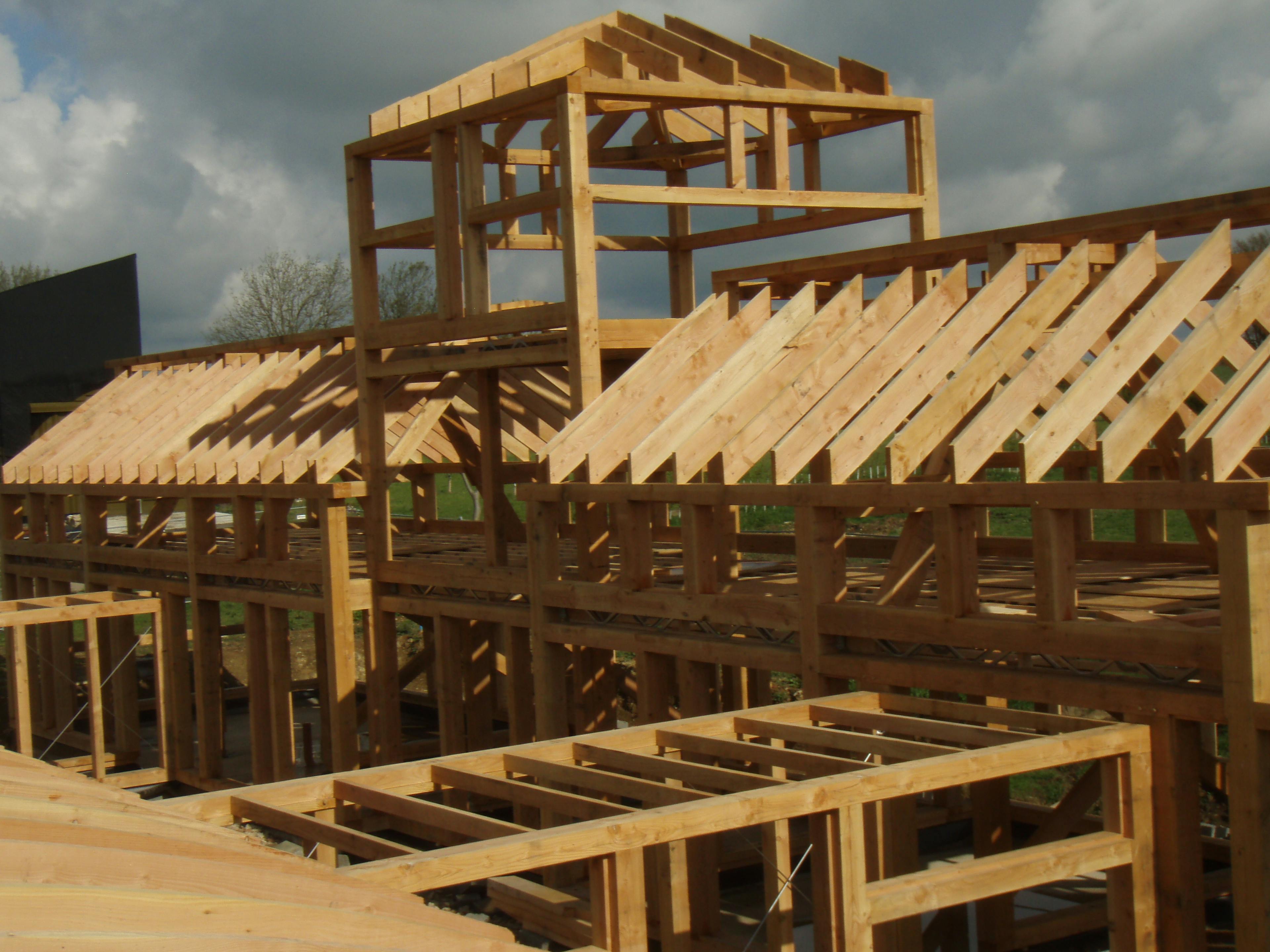 A Douglas fir framed large family farmhouse with a tower during installation