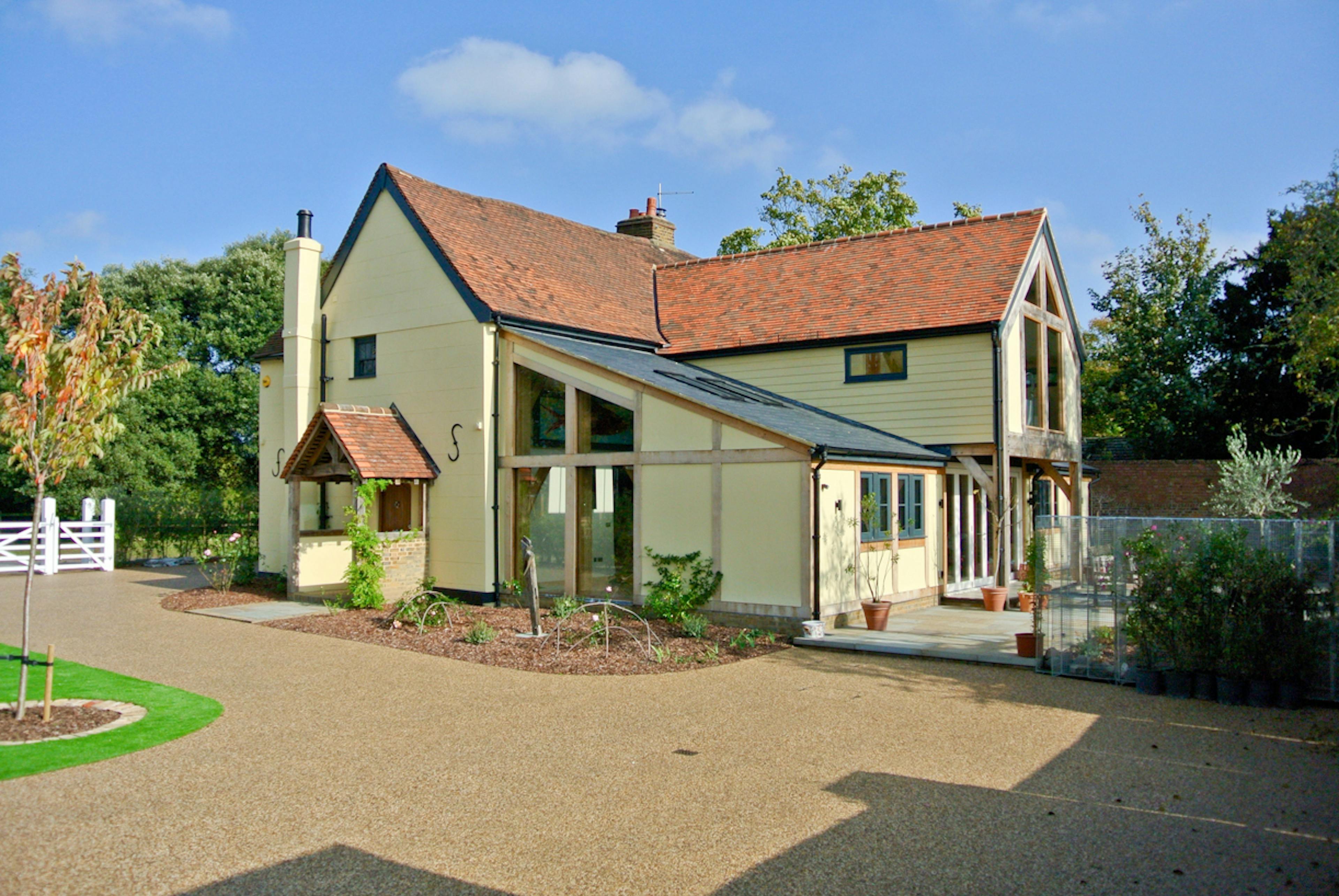 Exterior view of an oak framed extension to a 17th century pub set in a landscaped garden