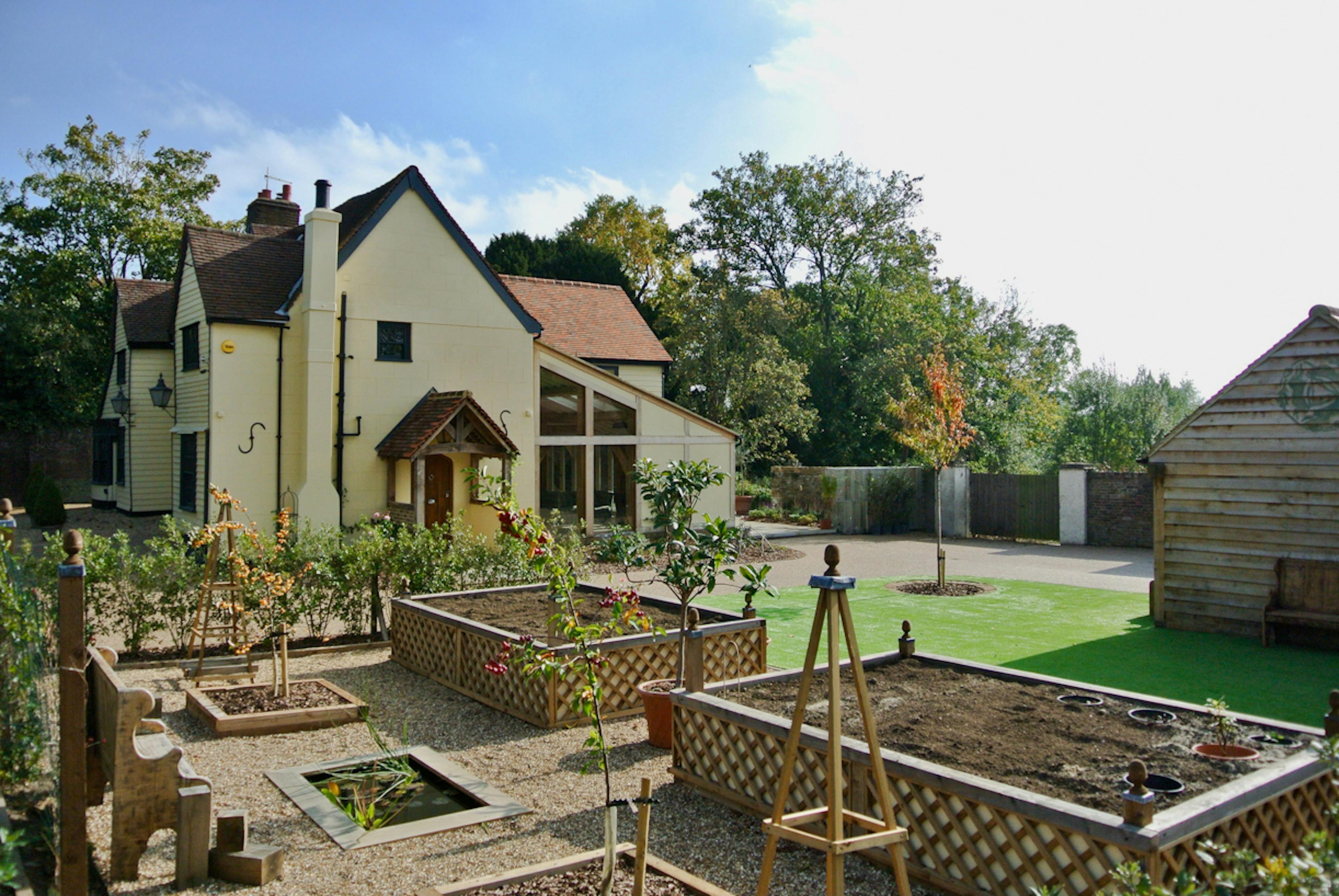 Exterior view of an oak framed extension to a 17th century pub set in a landscaped garden