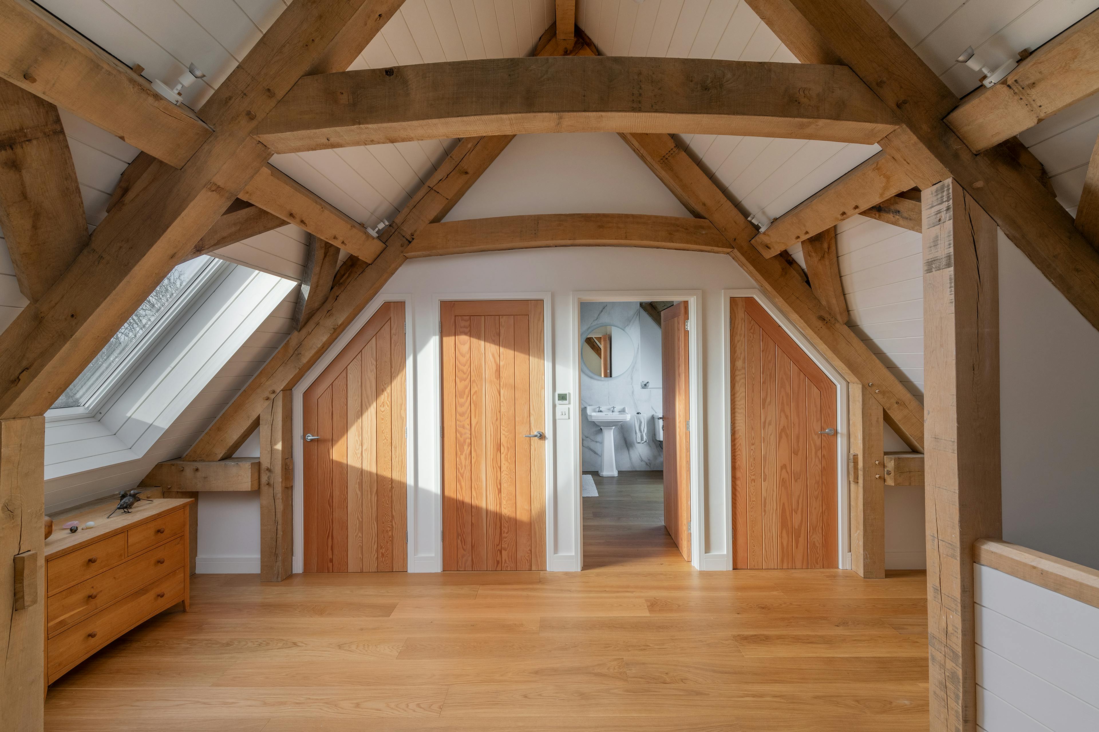 A mezzanine area landing in an oak frame home with a door to a shower room