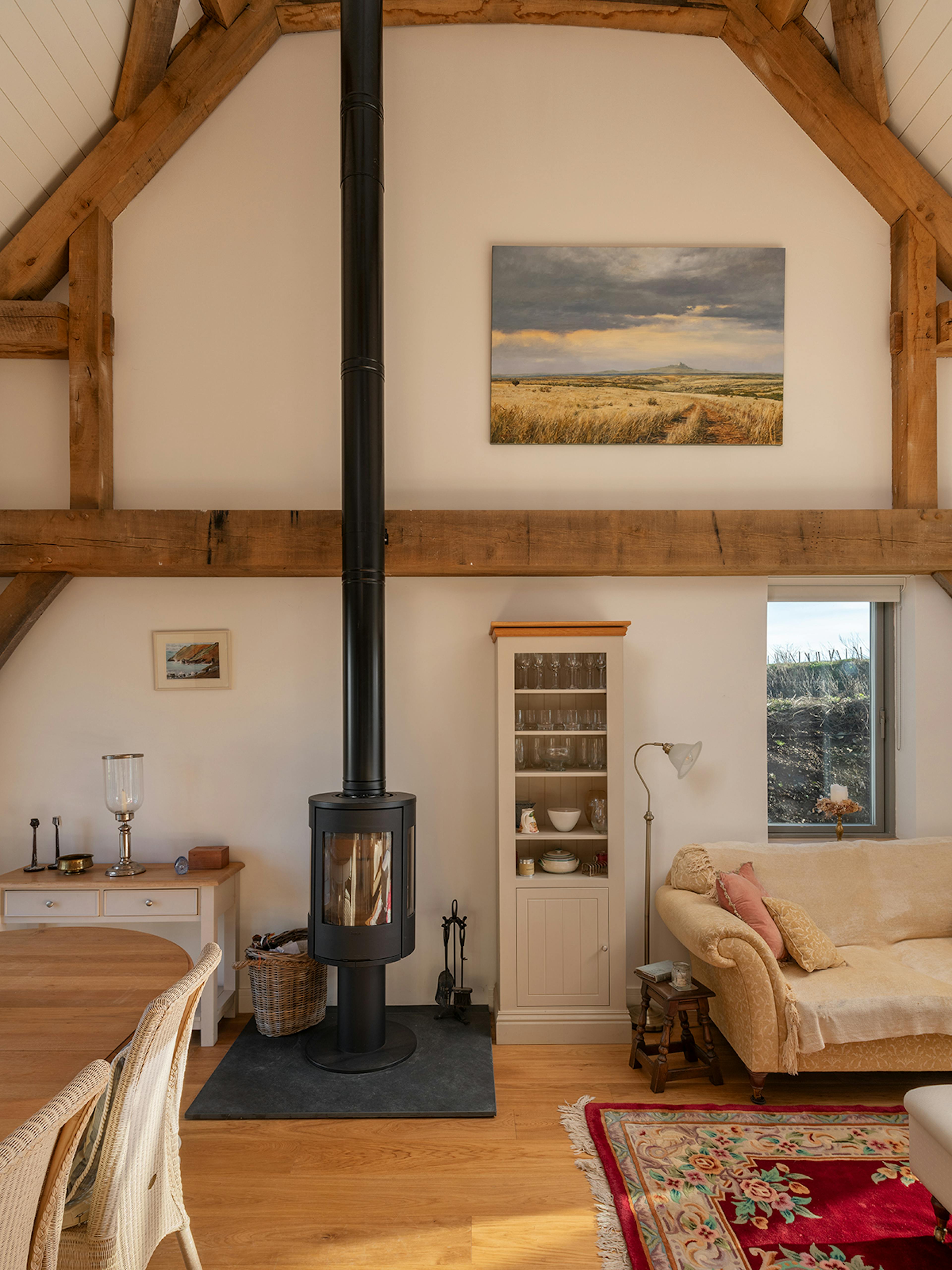 A dining and sitting area with a log burner in an oak framed home