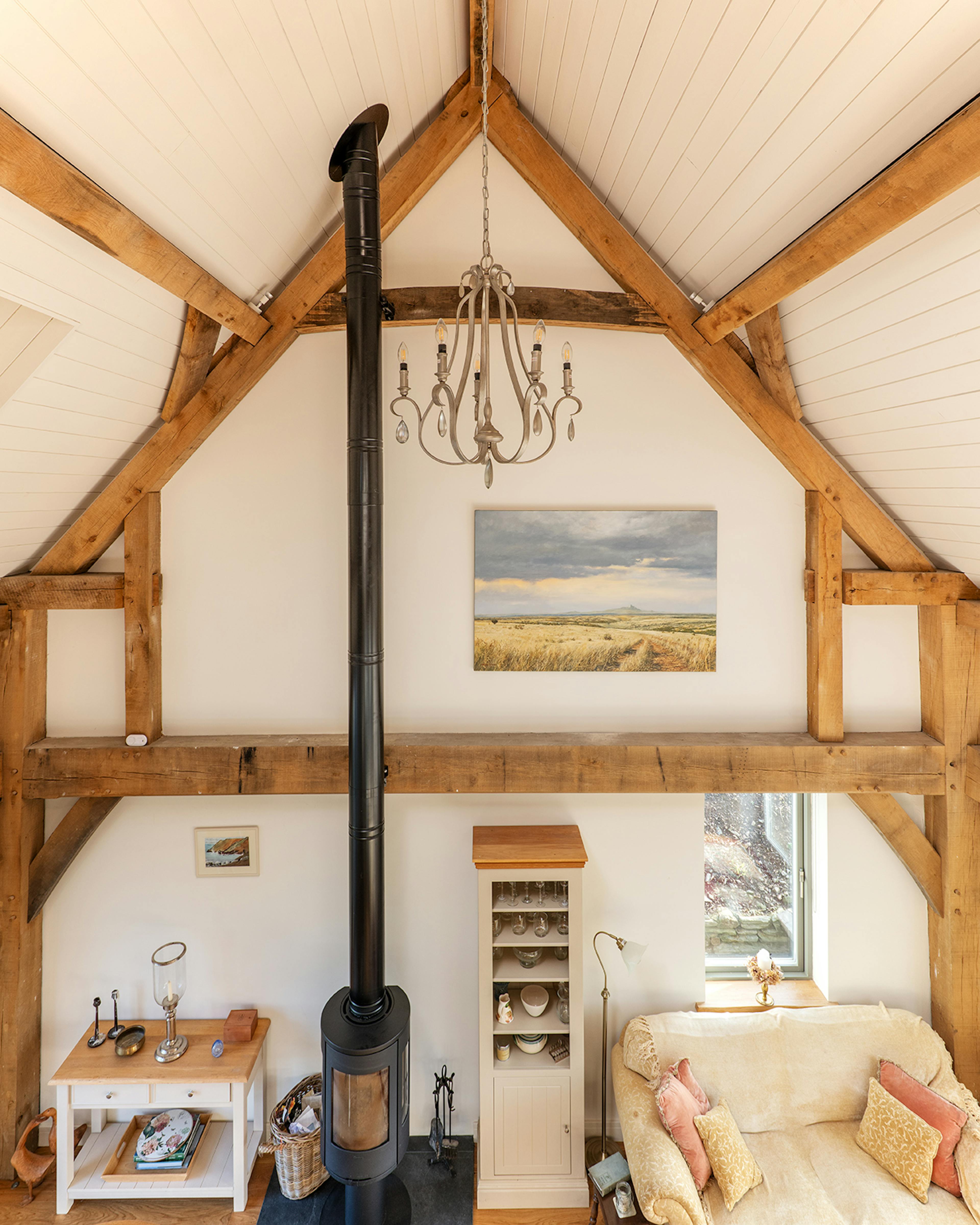 Looking down on to an open plan sitting area with a log burner in an oak frame home