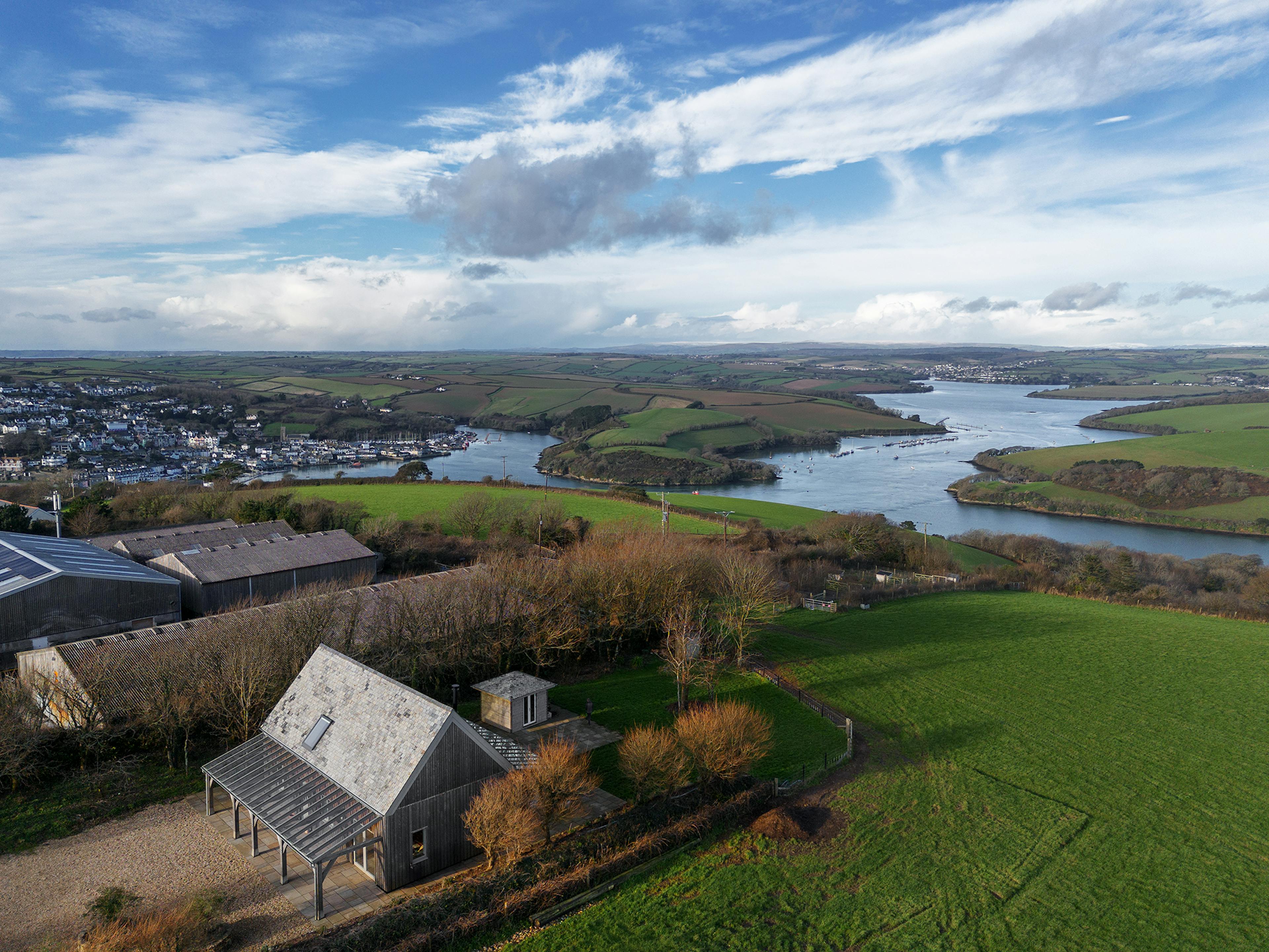 An aerial drone view of a farm with views of an estuary 