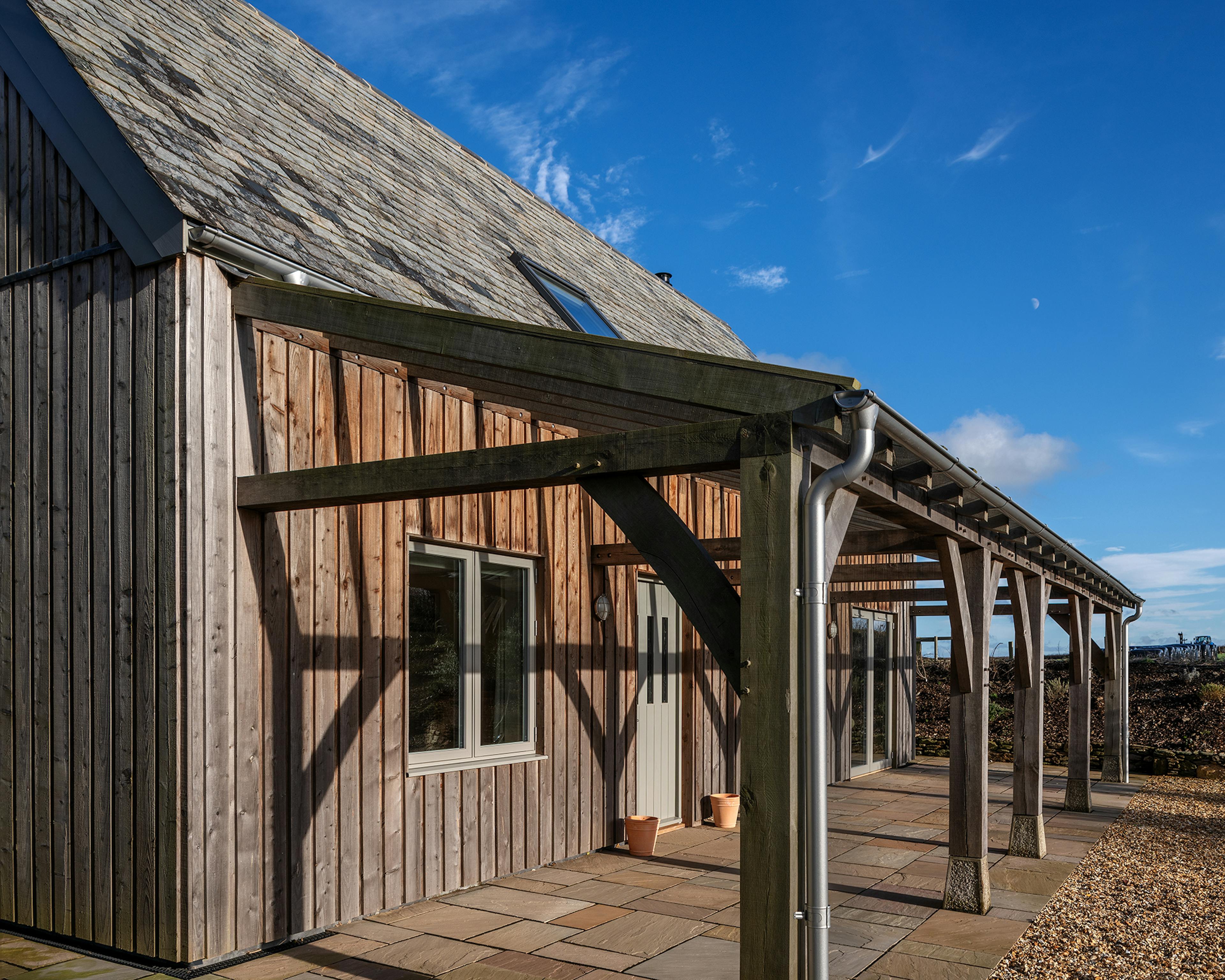 A timber clad oak frame home with an oak framed veranda 