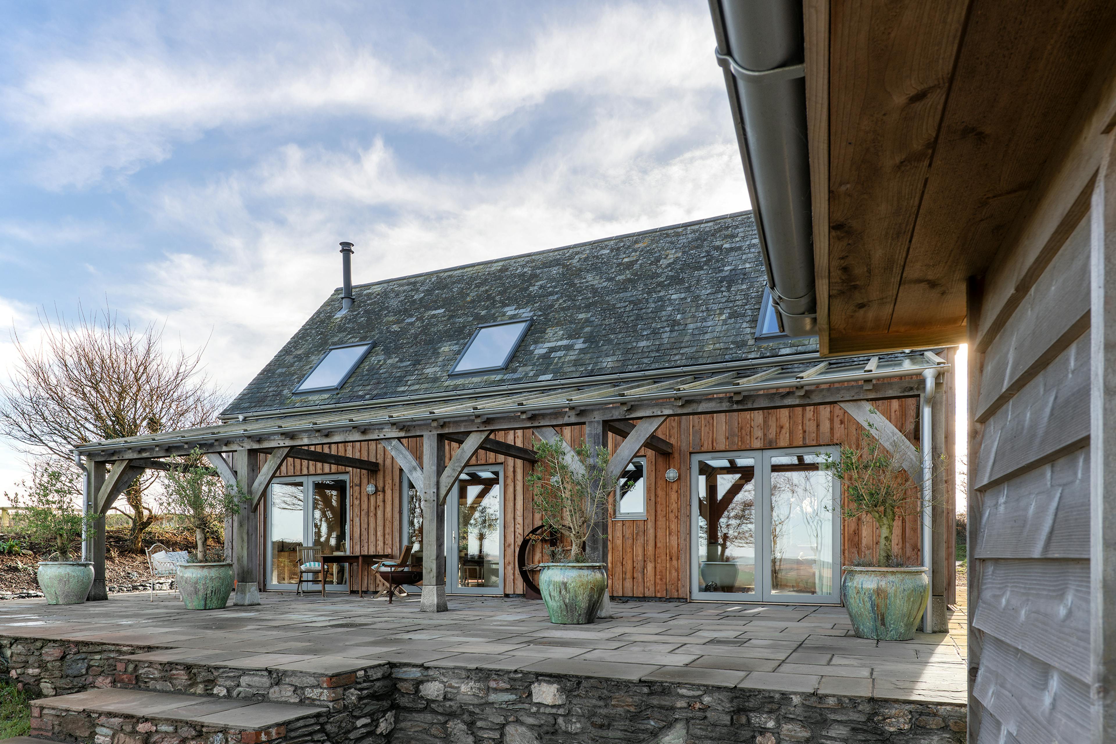 The rear of an oak frame home with an oak frame patio and oak frame veranda