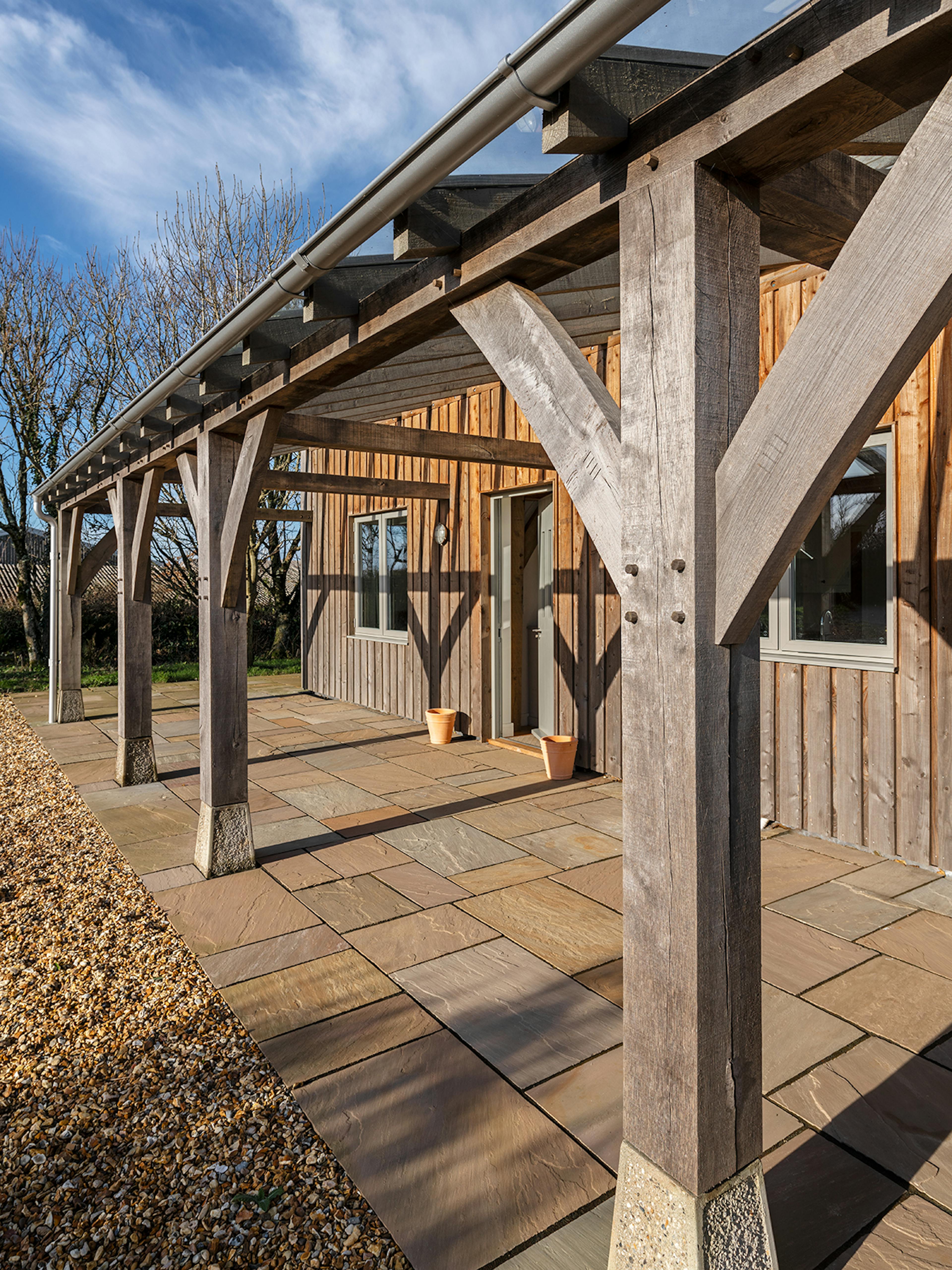 A timber clad oak frame home with a silvered oak framed veranda 