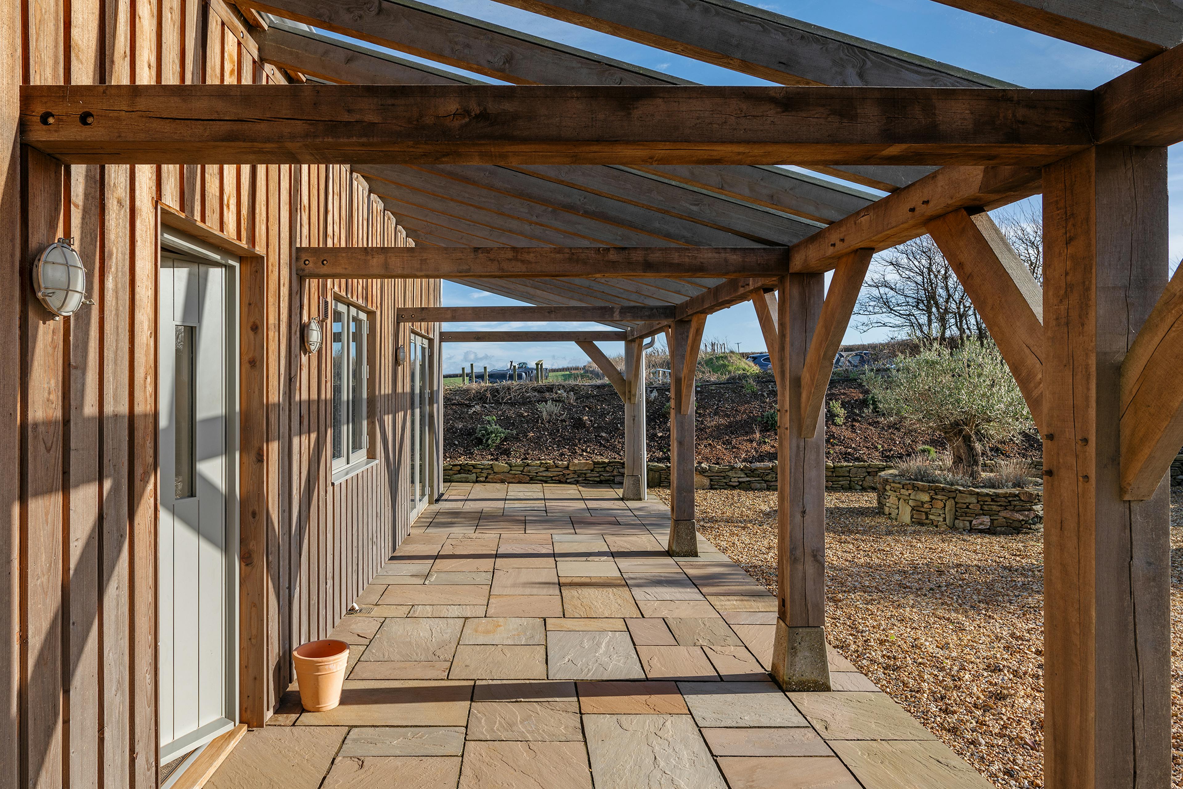 A timber clad oak frame home with an oak framed veranda