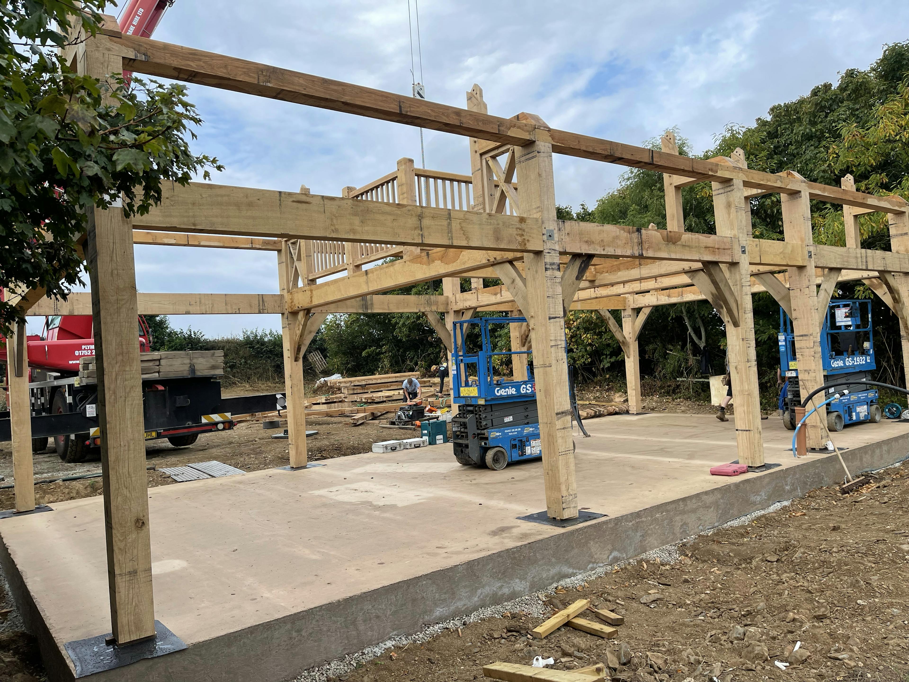 An oak frame for a home being installed with genie lifts