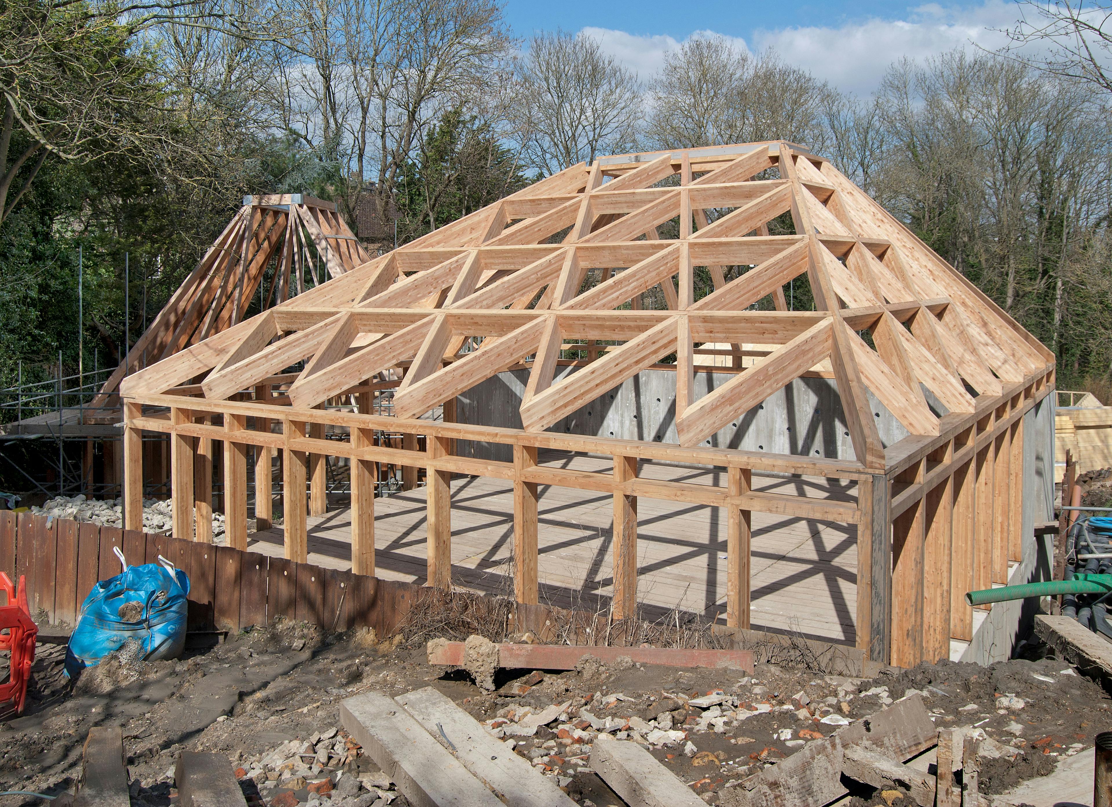 A larch glulam frame of a pyramidic building on a construction site during installation