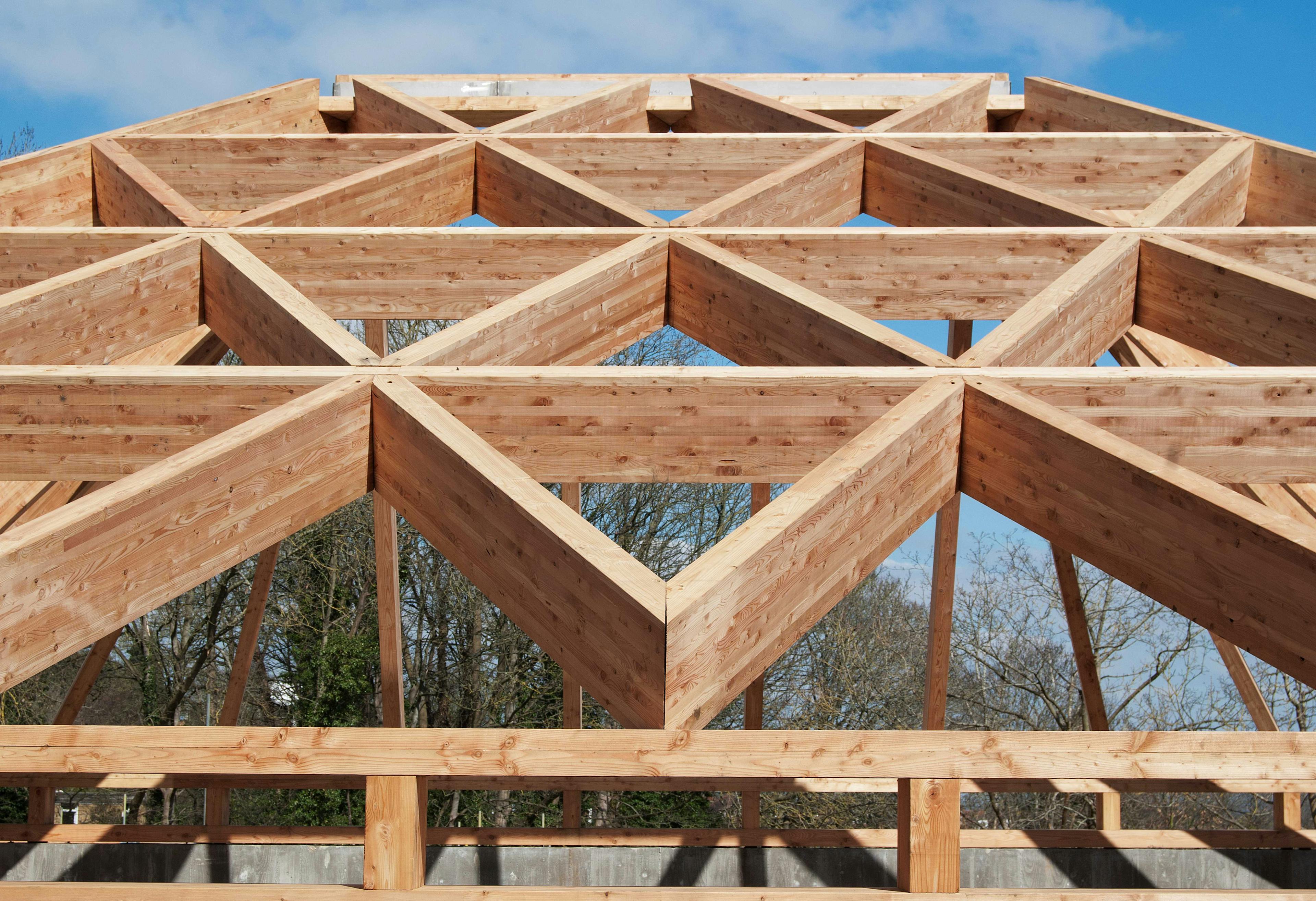 A larch glulam frame of a pyramidic building on a construction site during installation