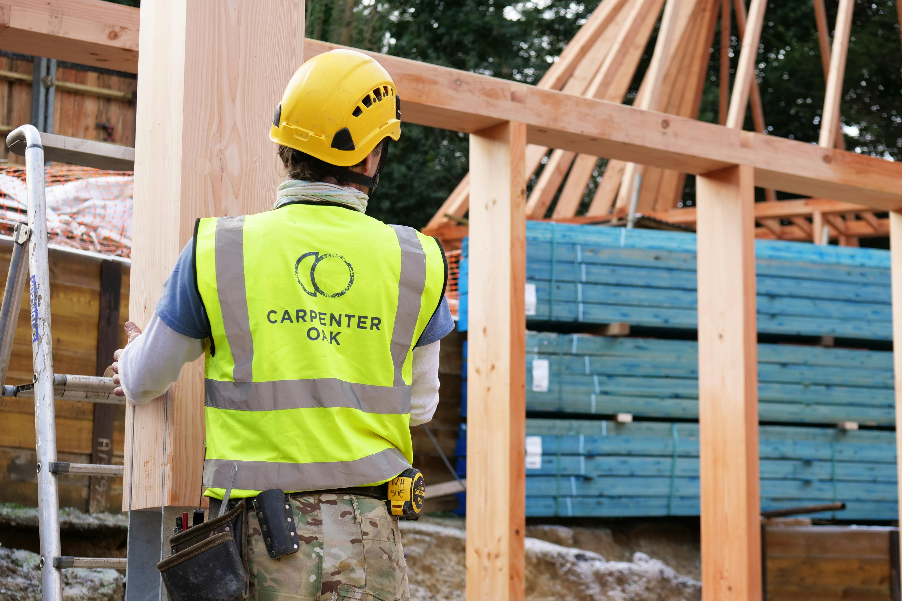 A carpenter and a Douglas fir framed building during installation