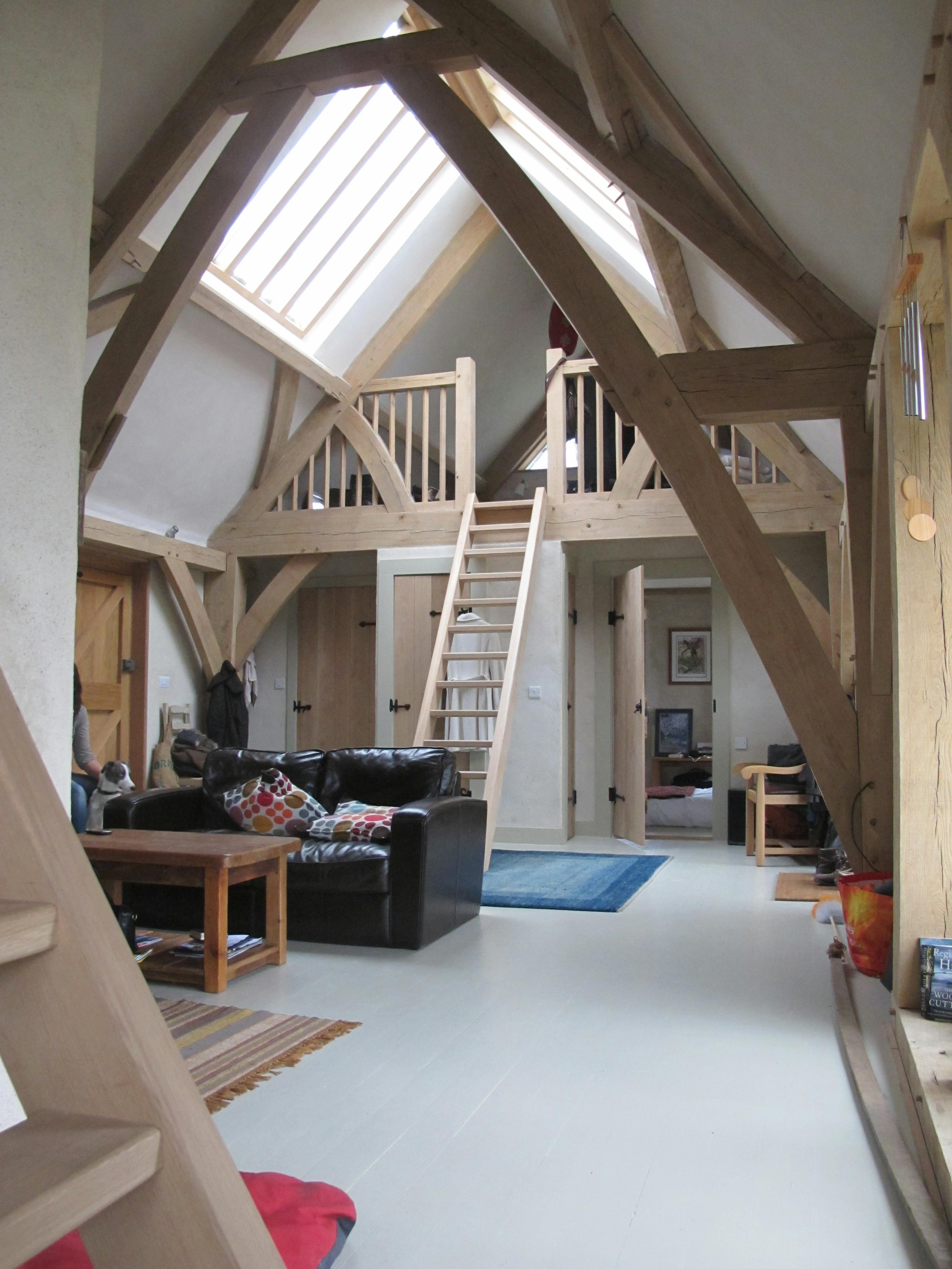 Completed interior of an oak-framed home in Cornwall, featuring a central mezzanine that maximizes space and enhances the open-plan design