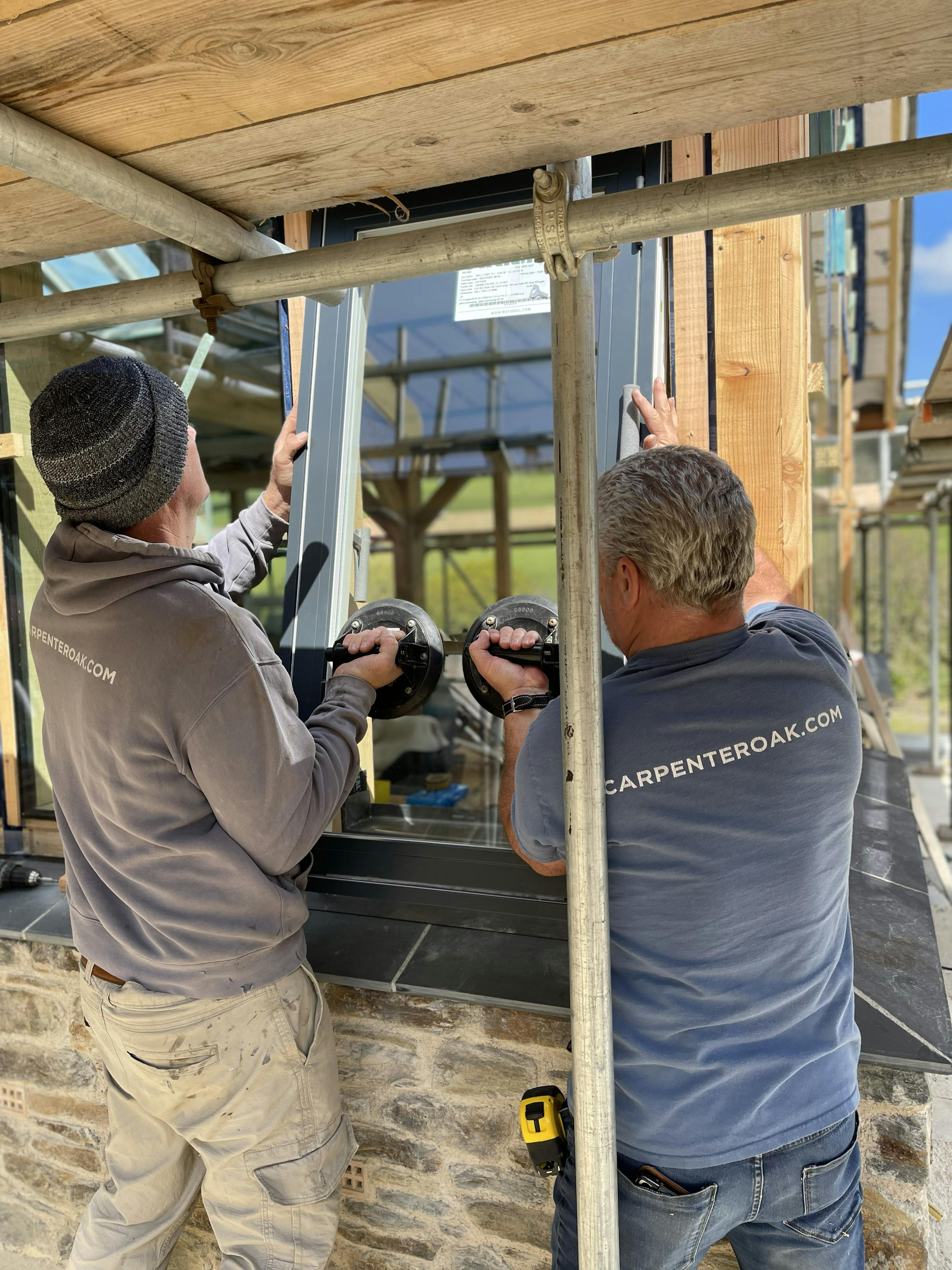 The glazing for an oak framed garden room, entrance and corridor extension being installed  