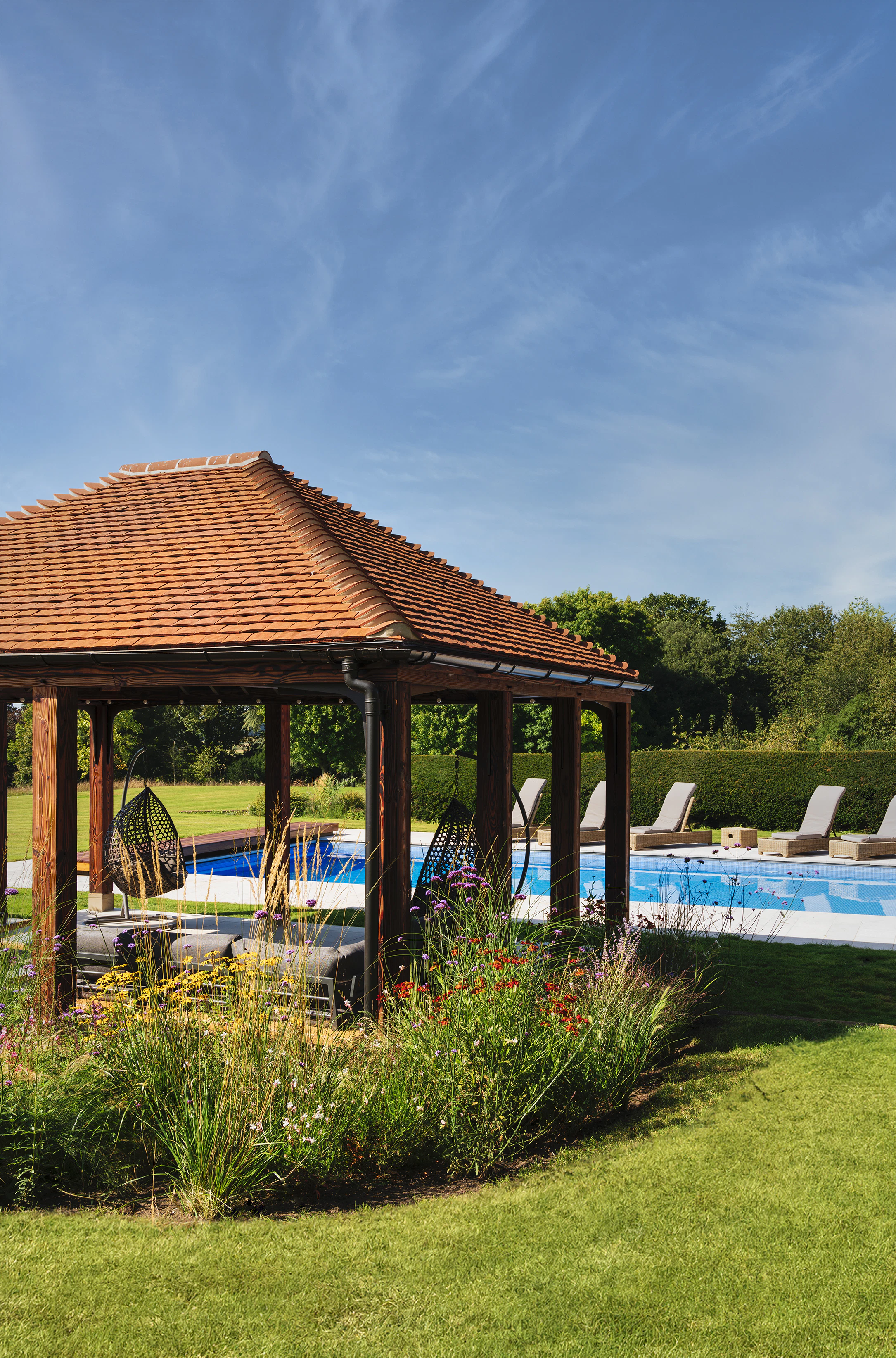 A charred Douglas fir framed garden annexe by a swimming pool