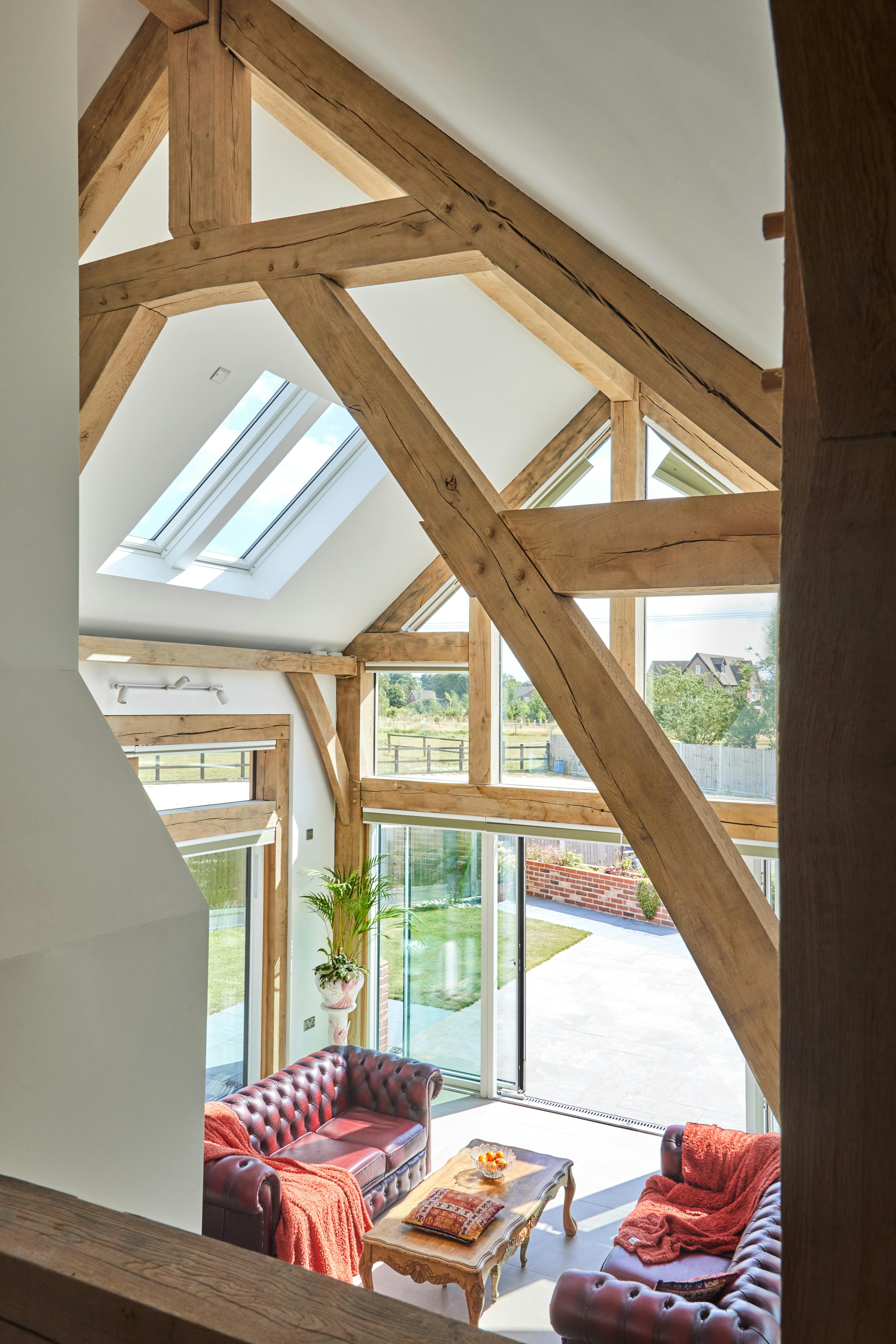 A double height oak framed open plan sitting room with a glazed gable end.