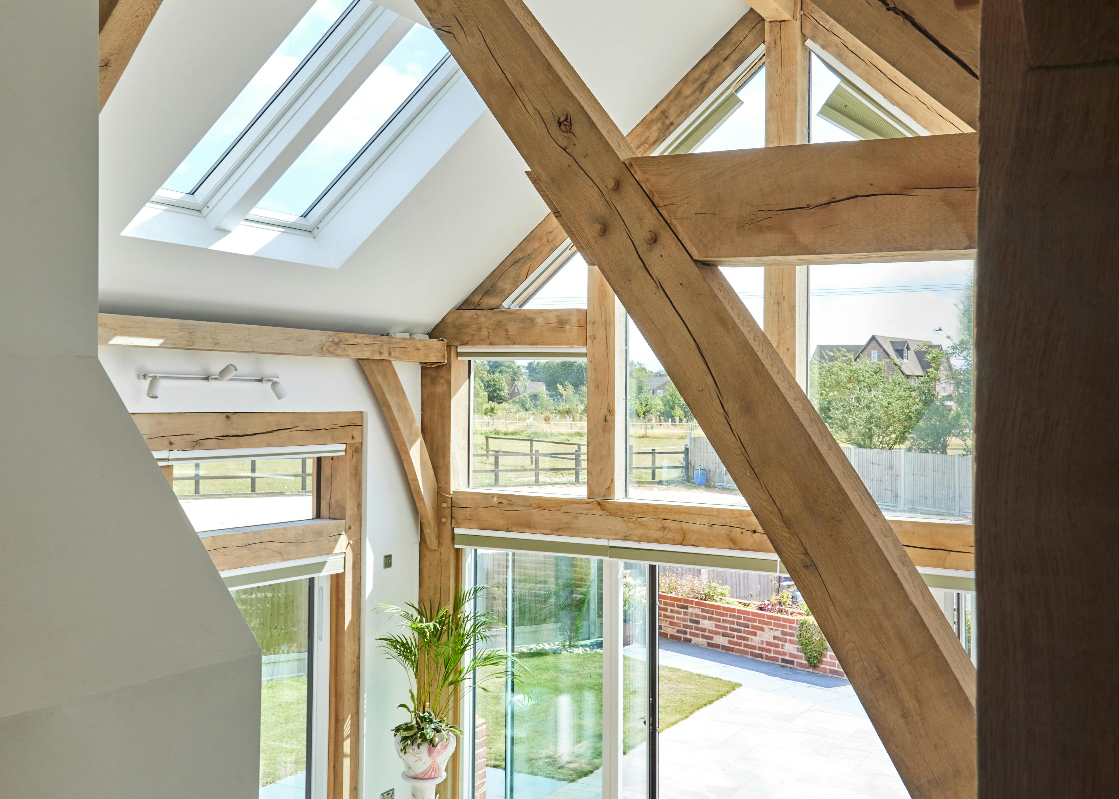 A double height oak framed open plan sitting room with a glazed gable end.