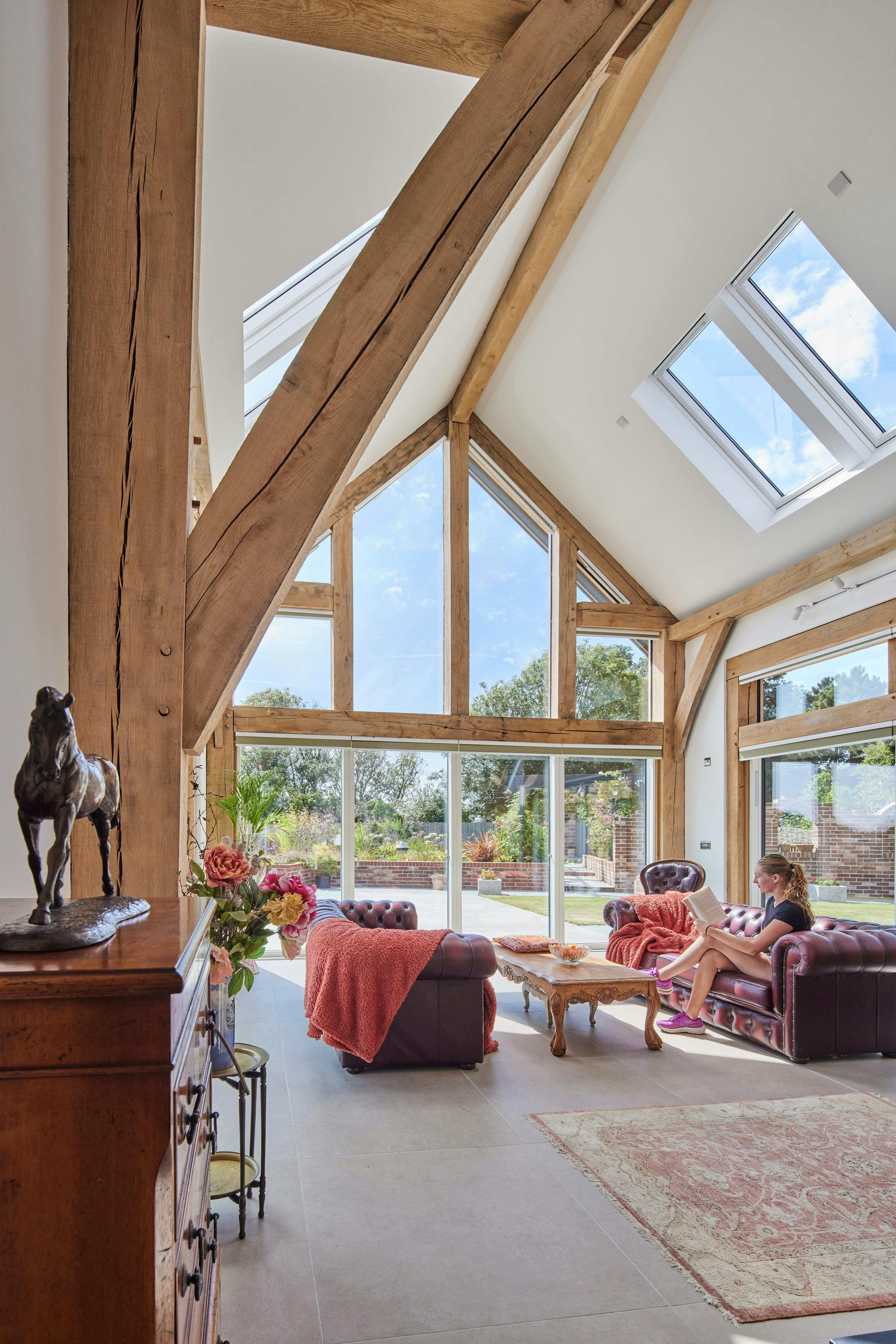 A double height oak framed open plan sitting room with a glazed gable end.