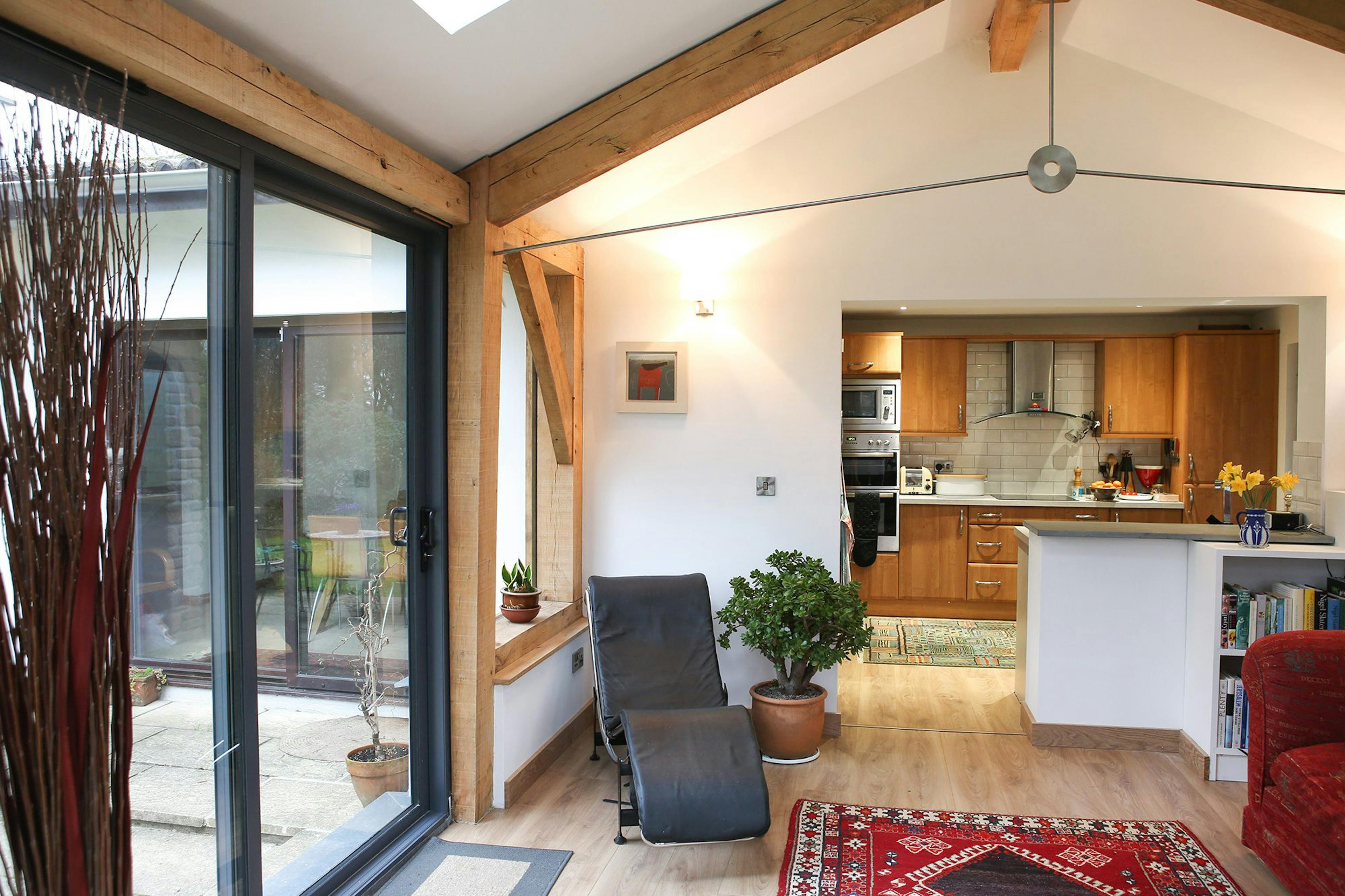 Oak-framed extension in Cornwall featuring a spacious open-plan living room and kitchen with large glazing, seamlessly connecting to the outdoor space