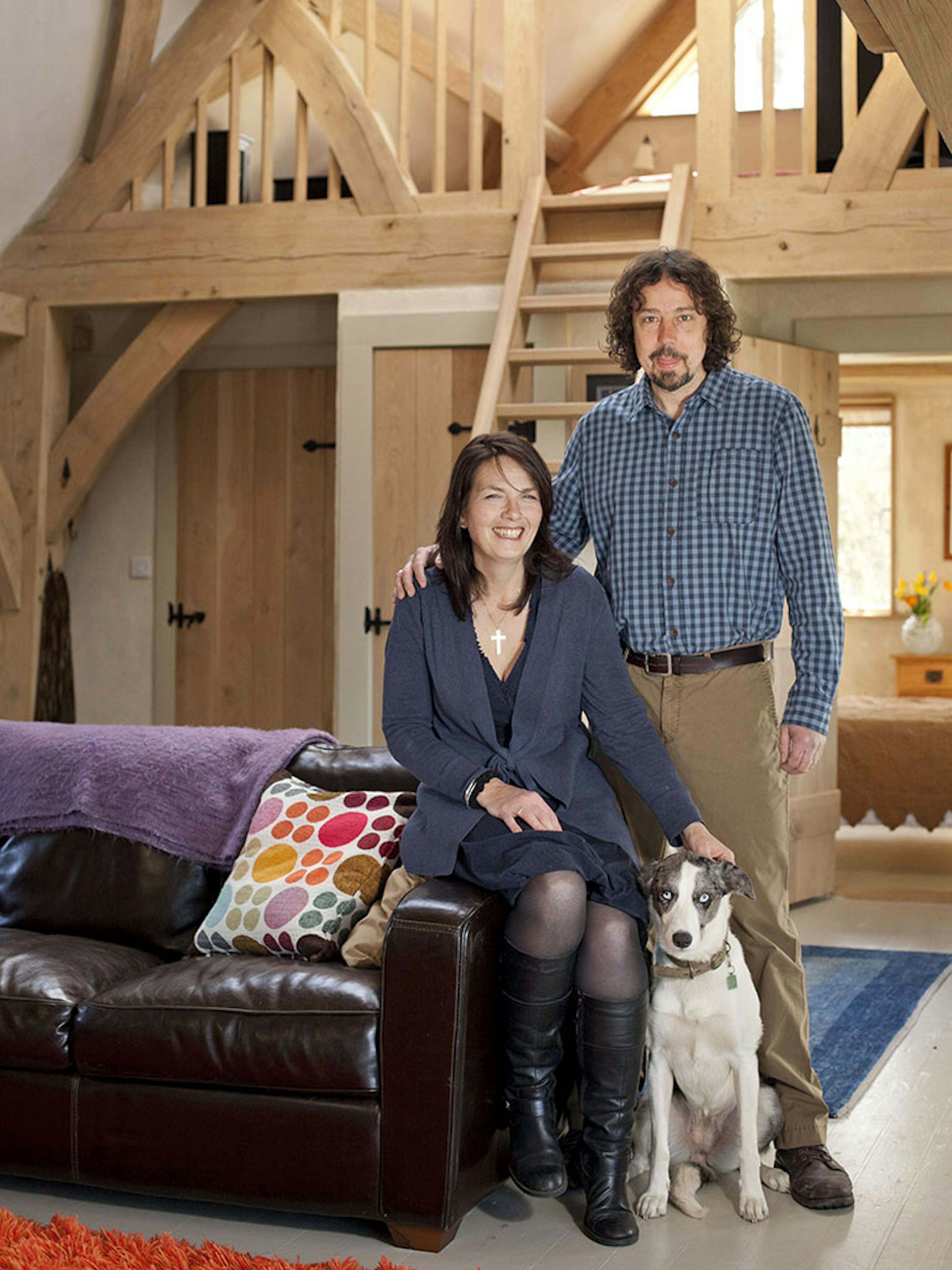 Completed interior of an oak-framed home in Cornwall, showcasing a lounge with a sling brace design, natural wood accents, and a comfortable, stylish atmosphere for the client