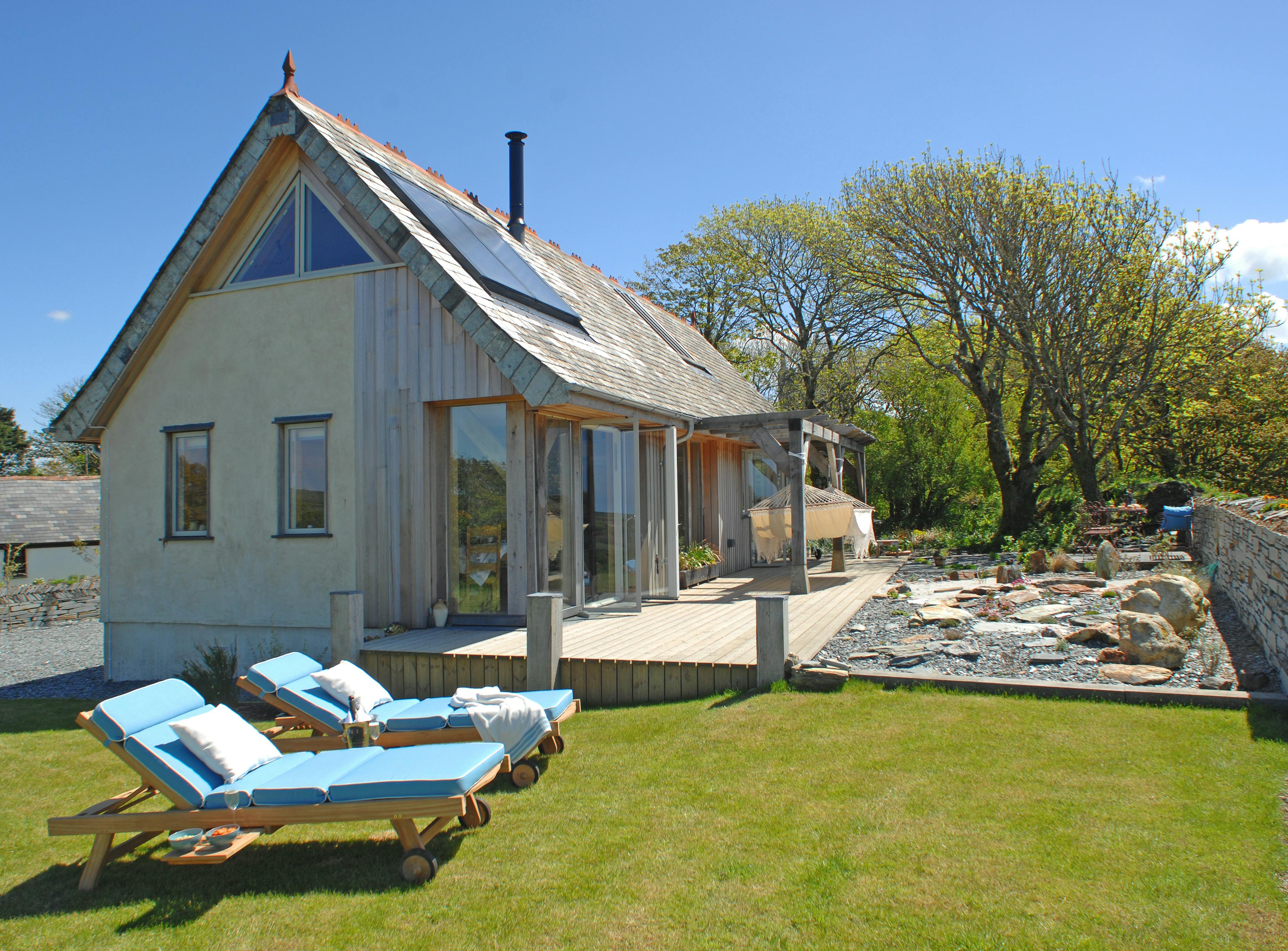 Completed oak-framed house in Cornwall with a charming exterior, nestled in a garden retreat for a peaceful and natural setting