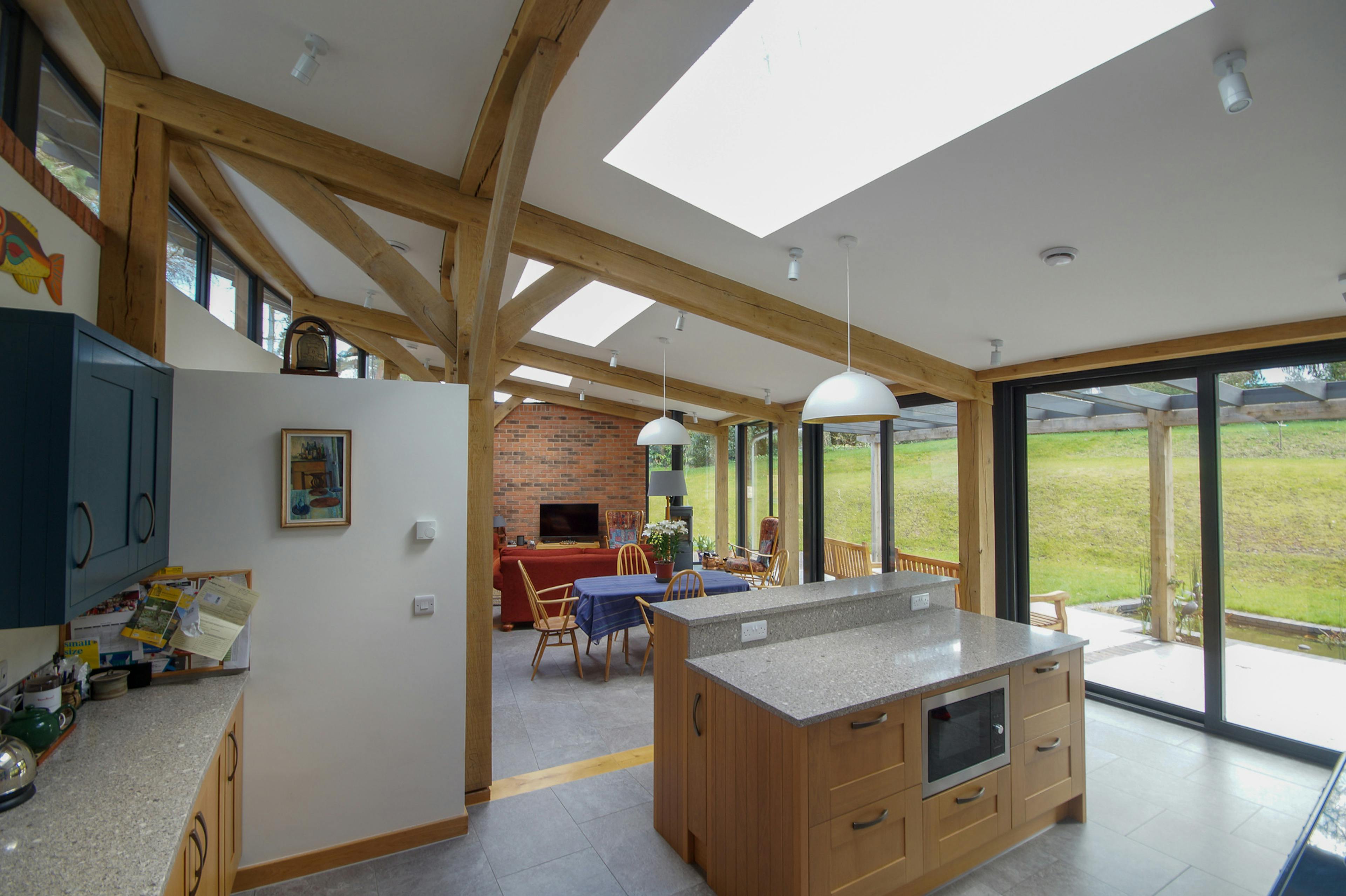 An open plan living room and dining area in a curved oak frame home