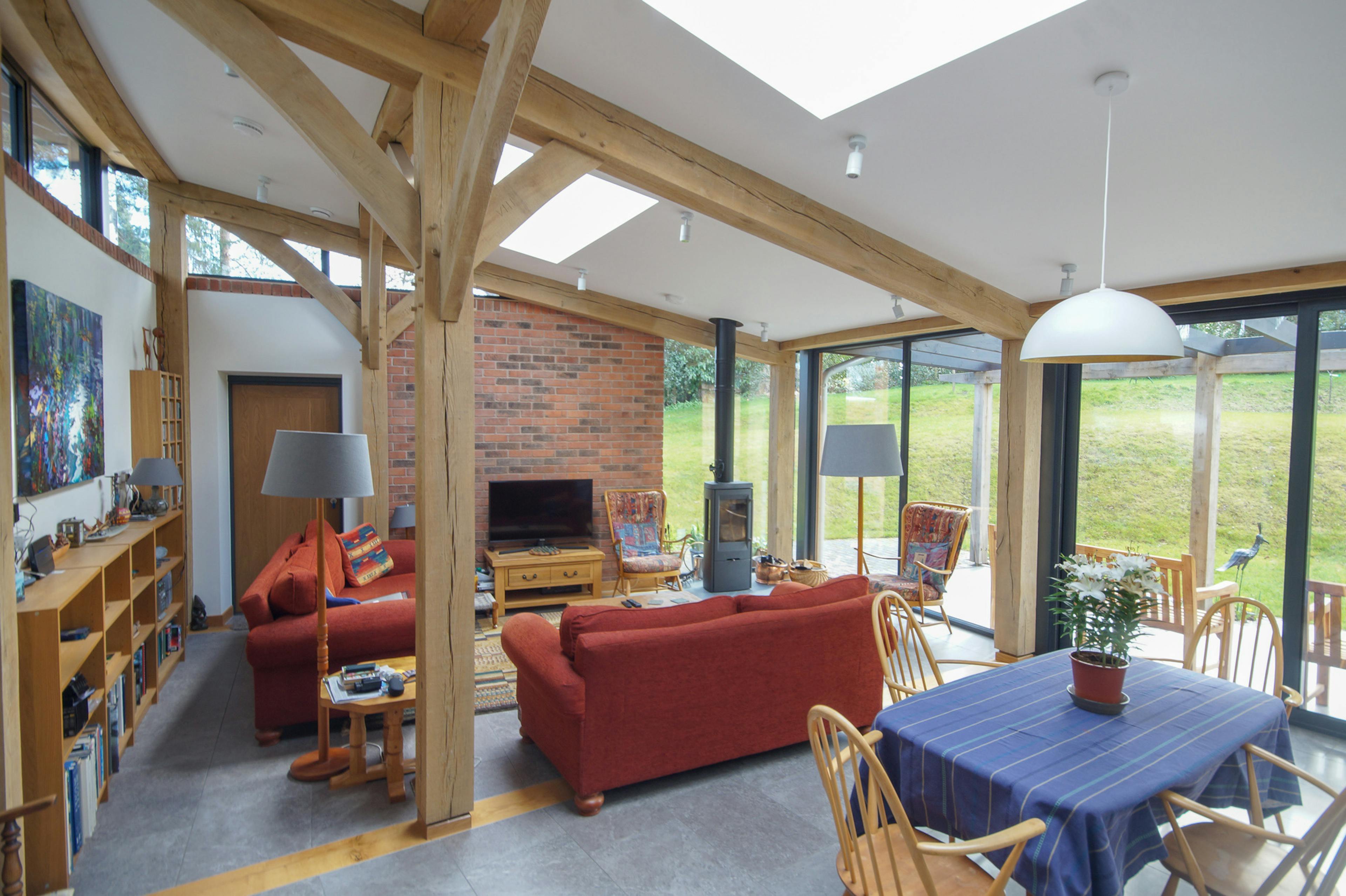 An open plan living room and dining area in a curved oak frame home