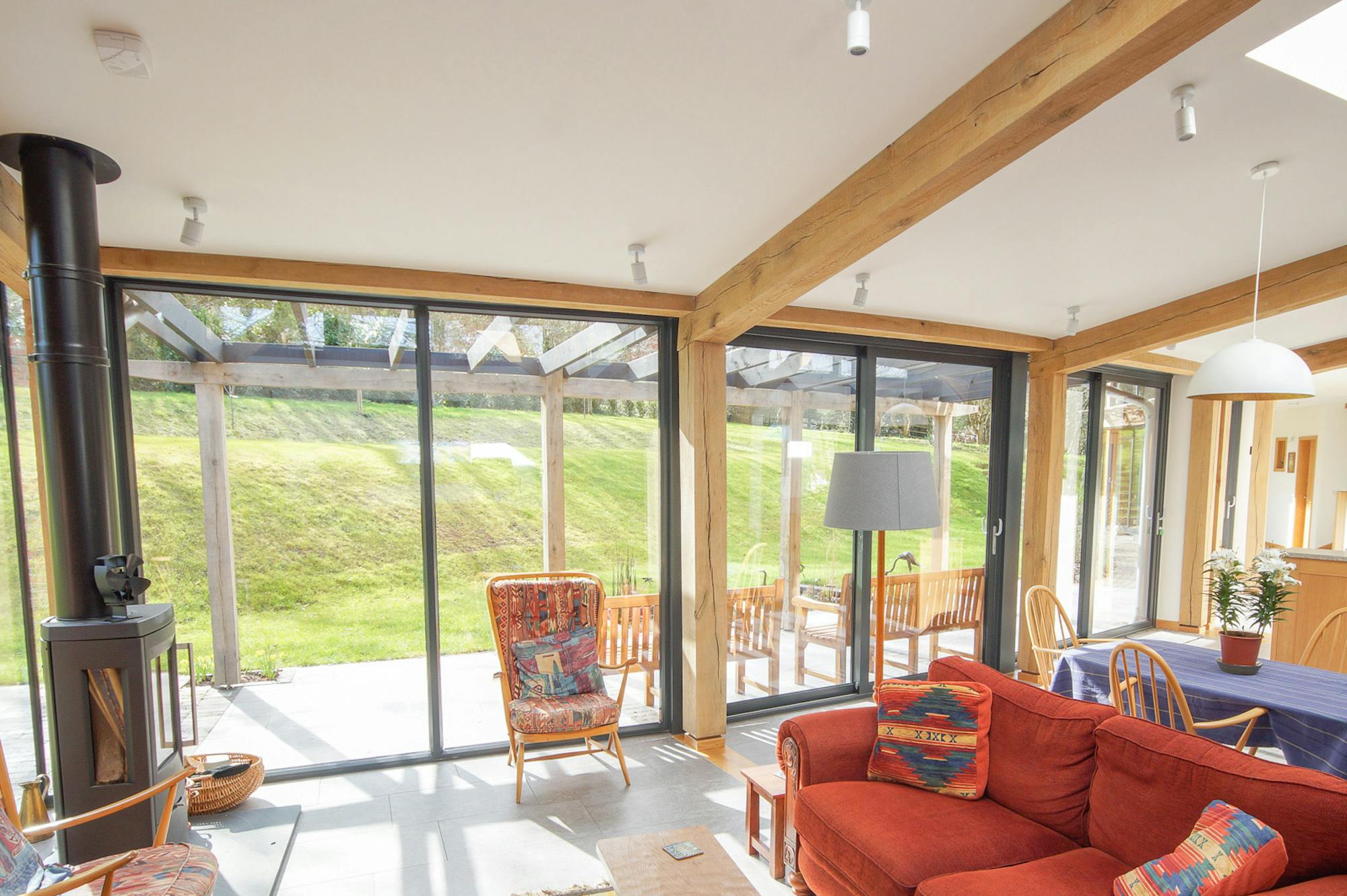 An open plan living room, kitchen, dining area in a curved oak frame home