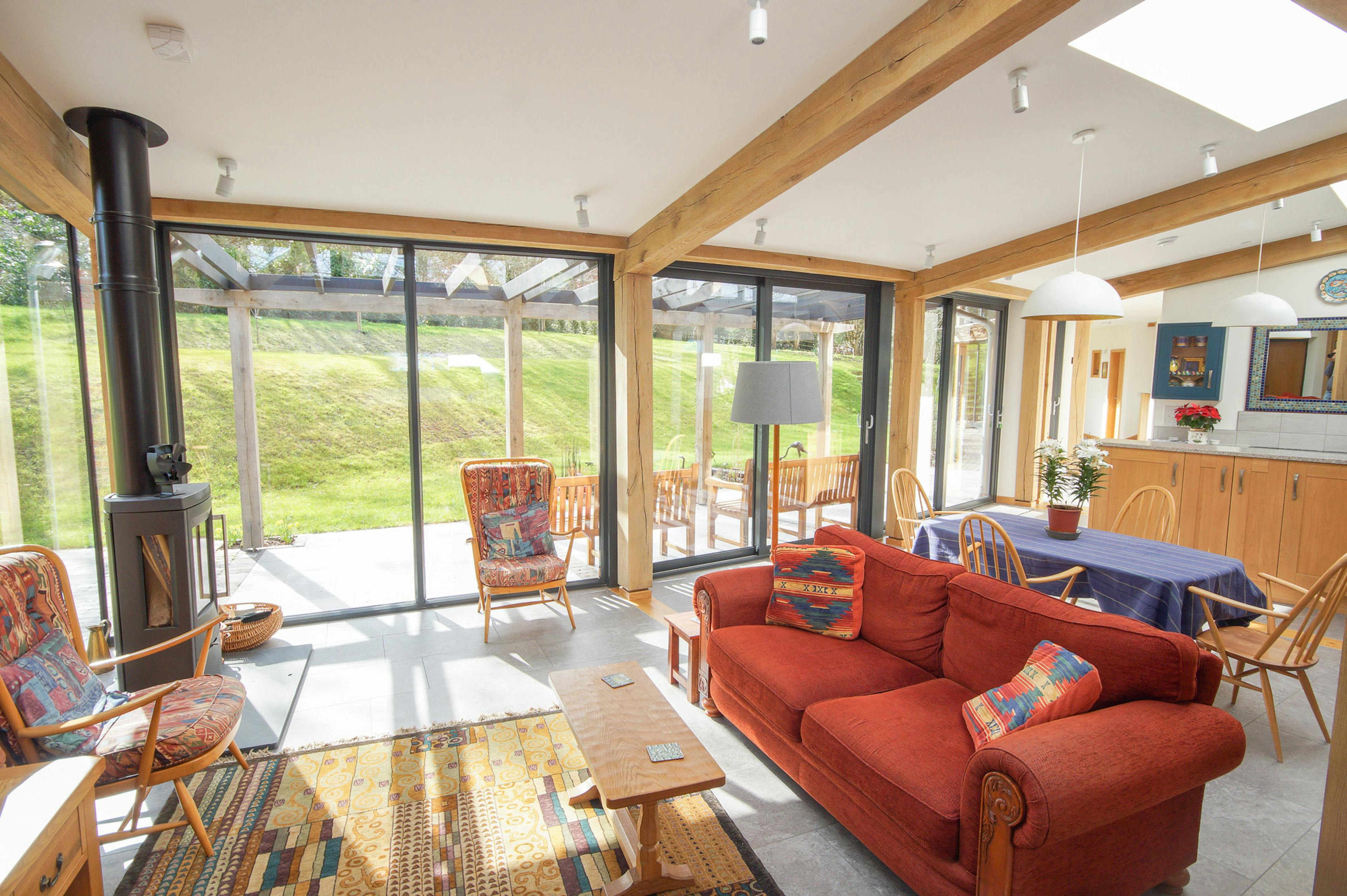 An open plan living room, kitchen, dining area in a curved oak frame home
