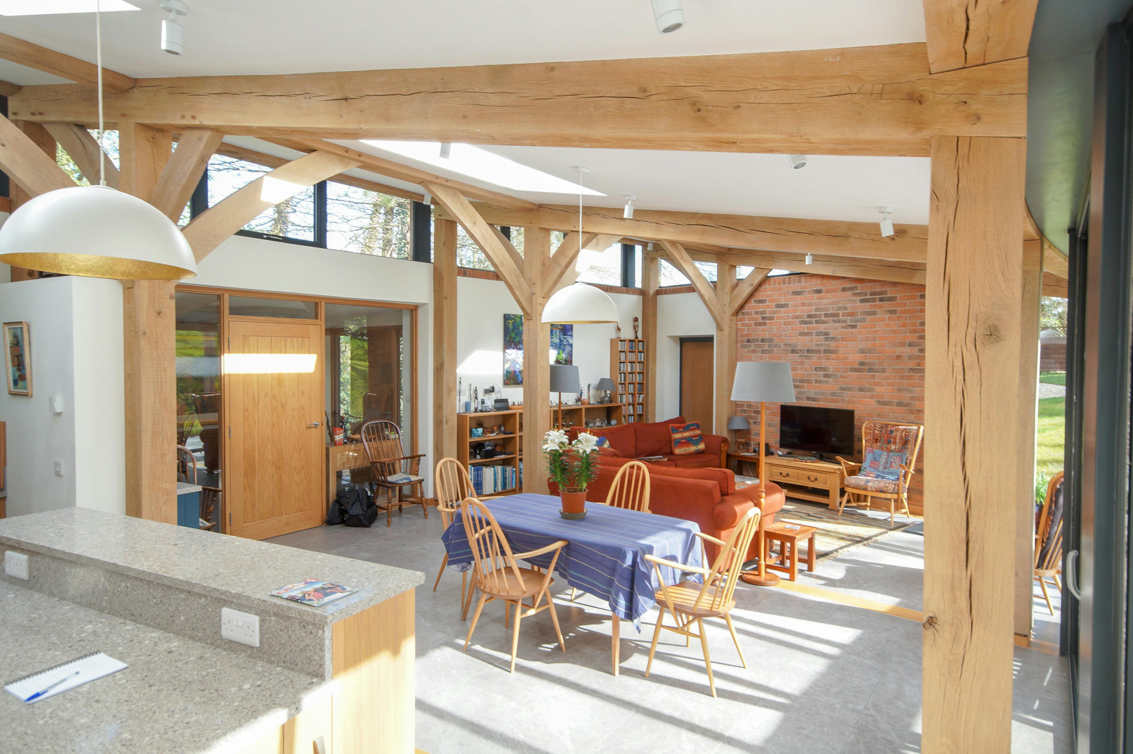 An open plan living room, kitchen, dining area in a curved oak frame home