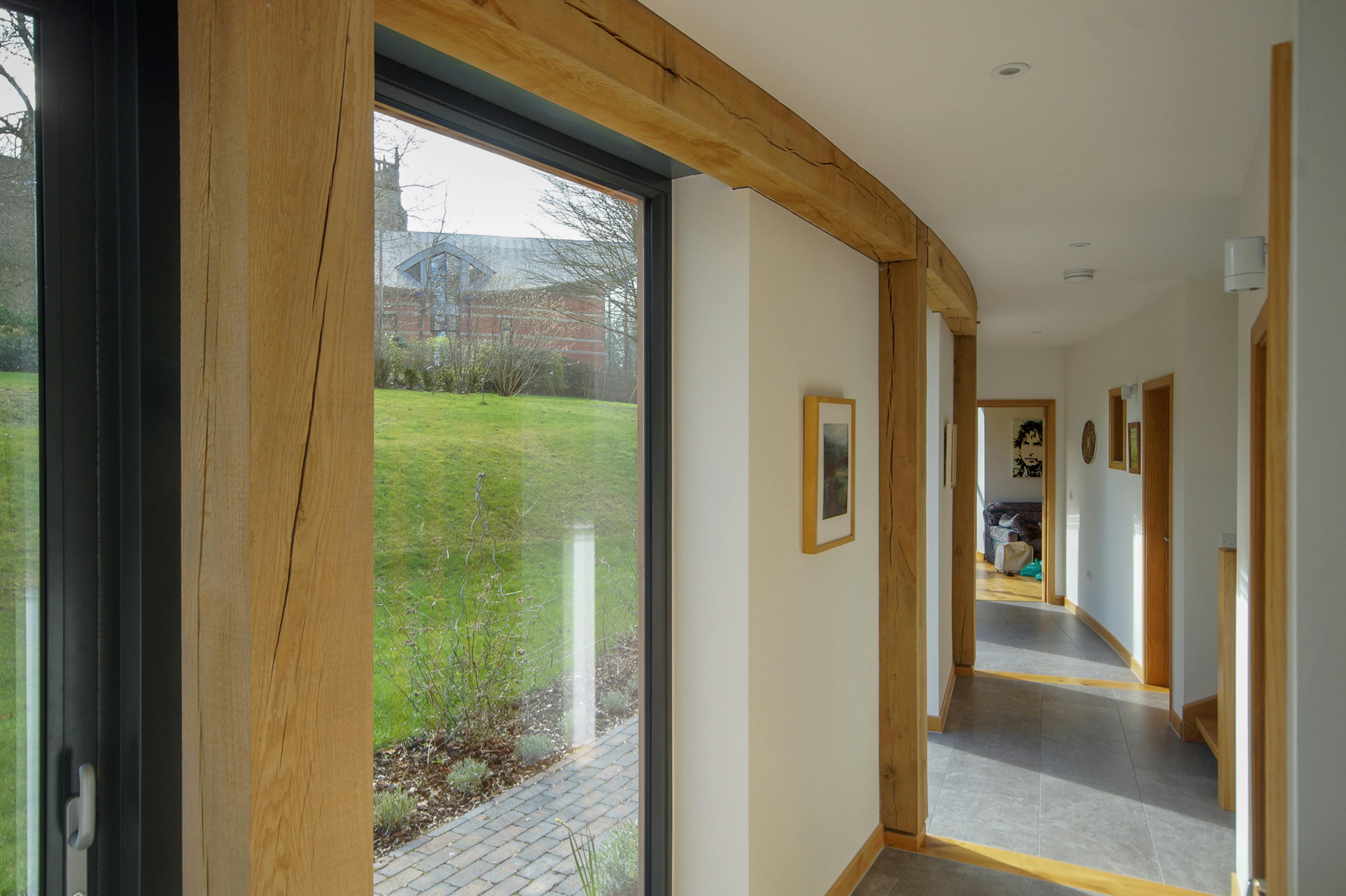 A corridor in a curved oak frame home